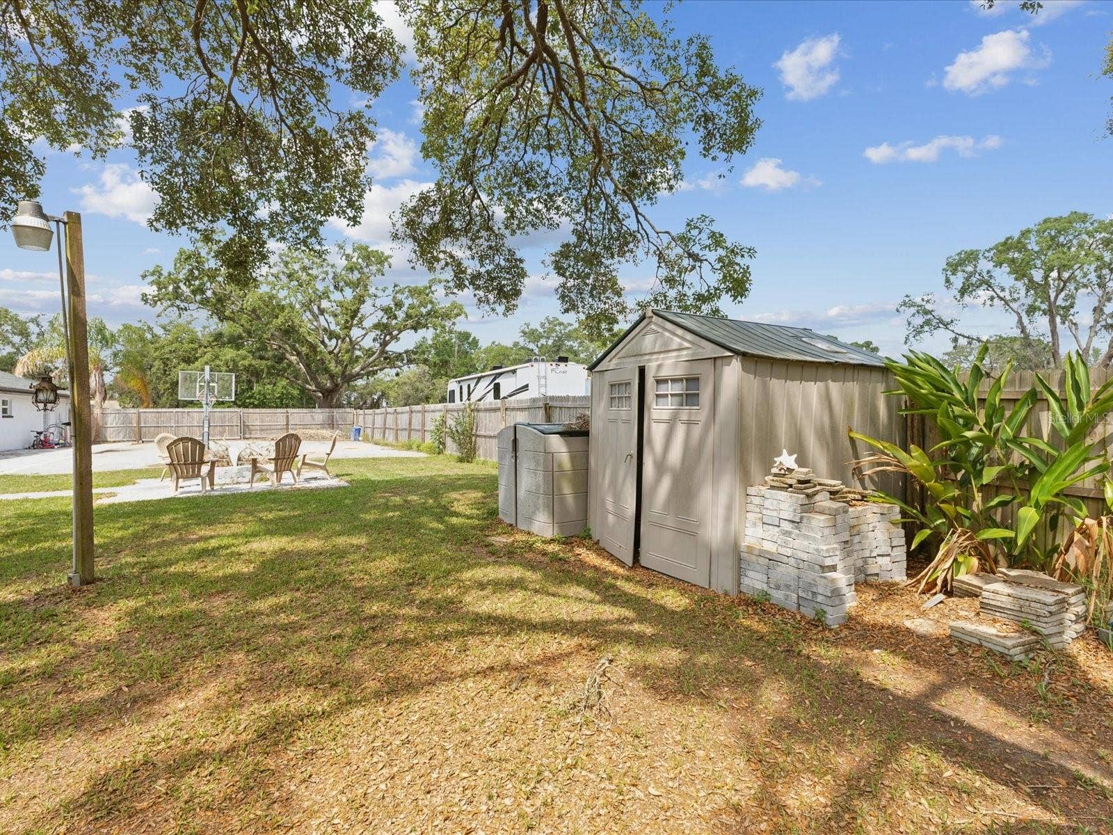 1222 HUNTINGTON AVENUE, Spring Hill, FL 34609 Backyard Storage and Fire Pit Seating Area