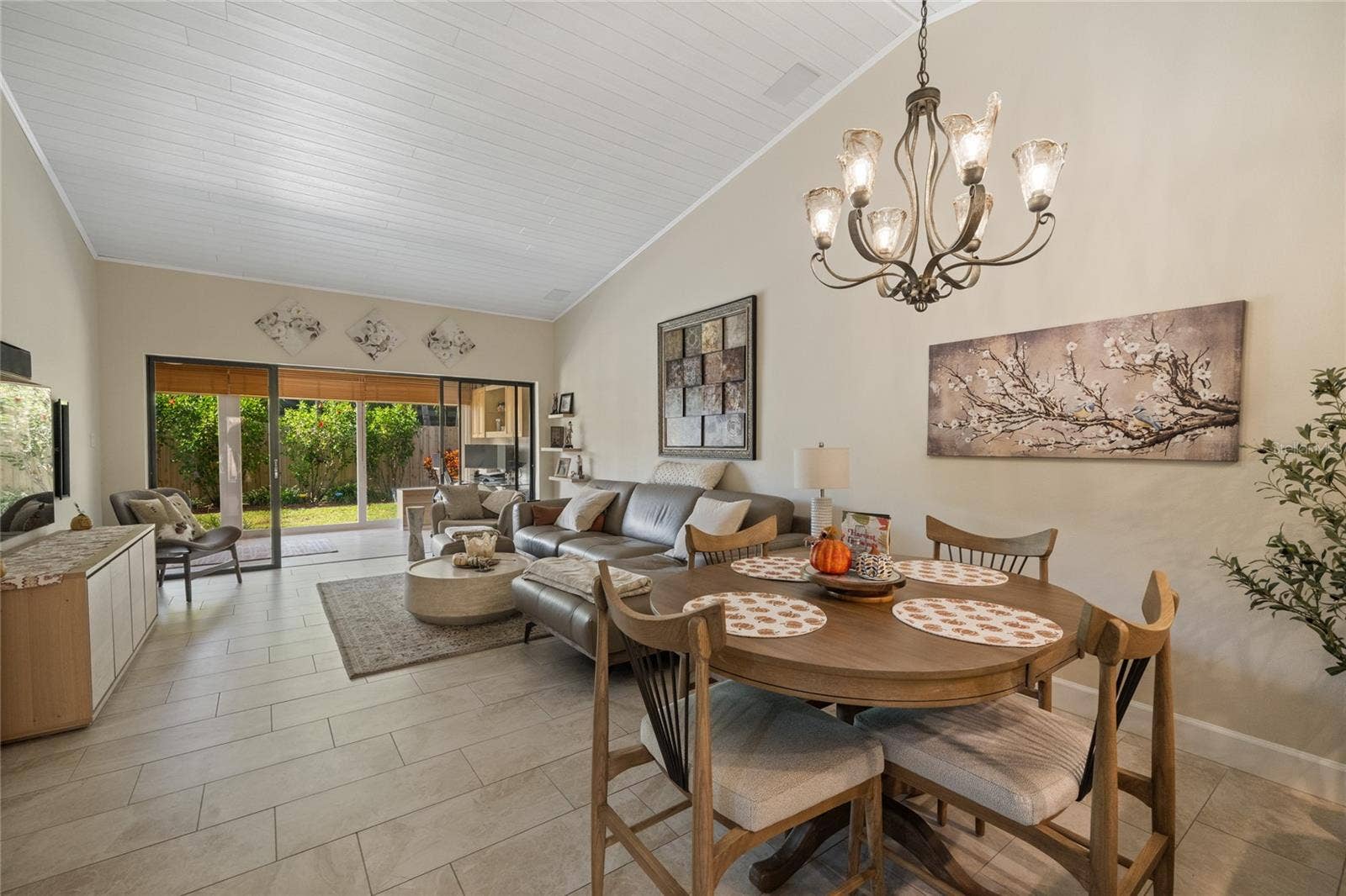 GREAT ROOM/LIVING ROOM AND DINING AREA WITH VIEW OUT TO ENCLOSED LANAI
