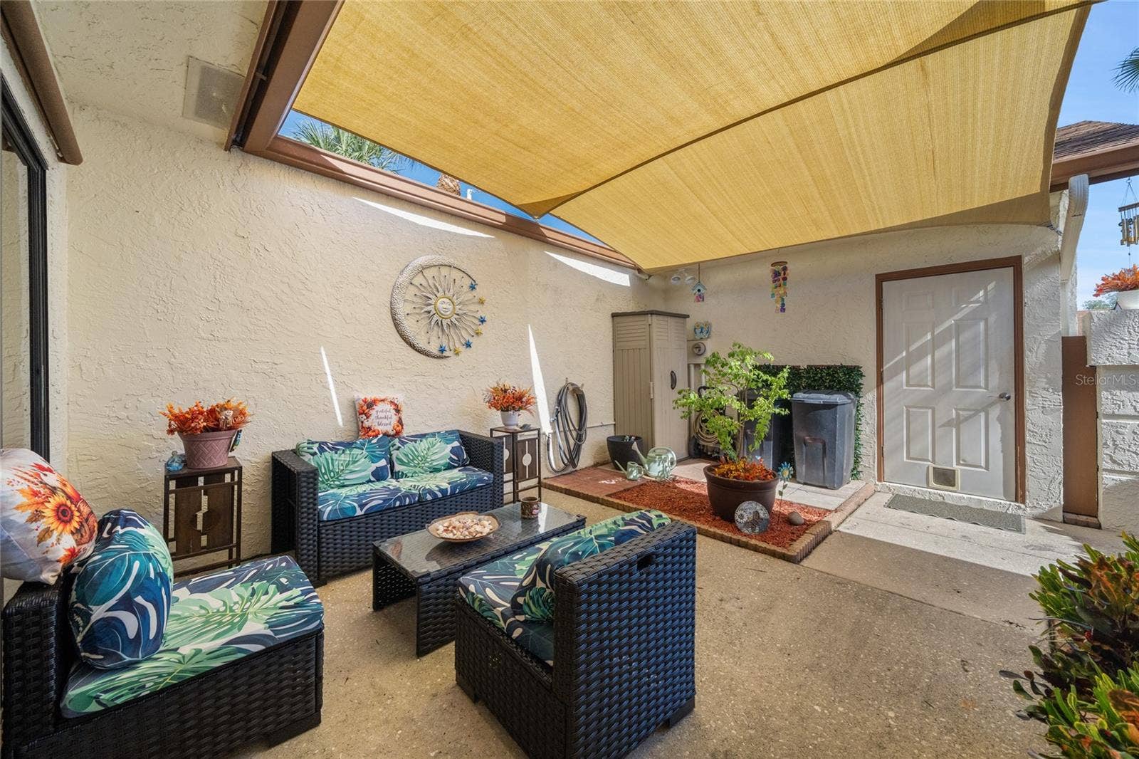 FRONT COURTYARD WITH SAILS.  DOOR LEADS INTO THE 1-CAR GARAGE.