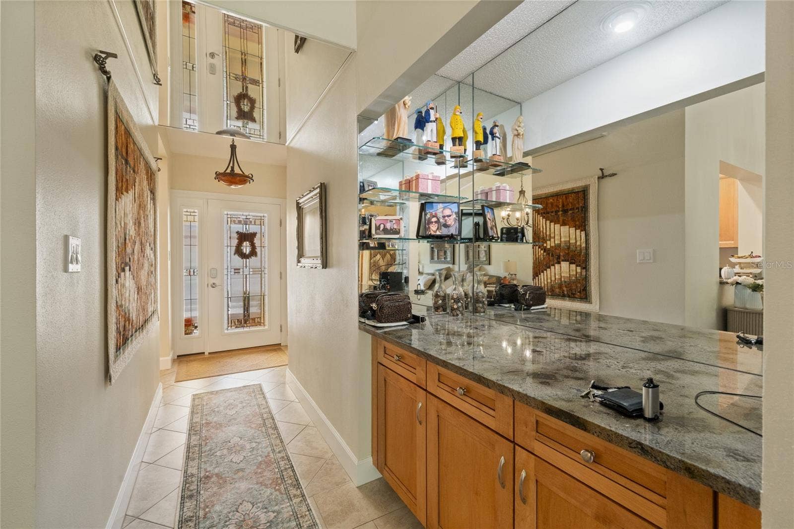 FRONT ENTRYWAY WITH CUSTOM DOOR W/LEADED GLASS AND SIDELIGHT.   MIRROWED AND LIGHTED BAR WITH GRANITE COUNTERTOP.