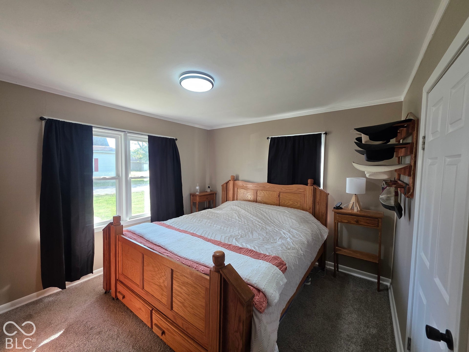 Neutral wall finishes, plush carpeting, double-hung windows, and a flush-mount ceiling light fixture