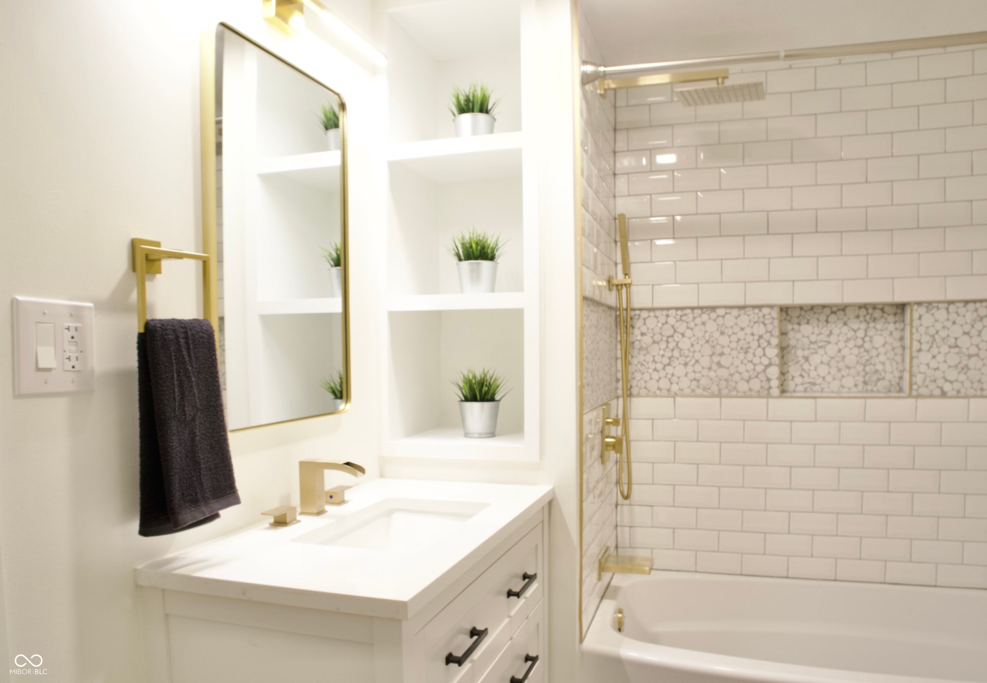 474 N Randolph Street, Indianapolis, IN 46201 Full bath with a tub/shower combo, built-in shelves, and gold fixtures.