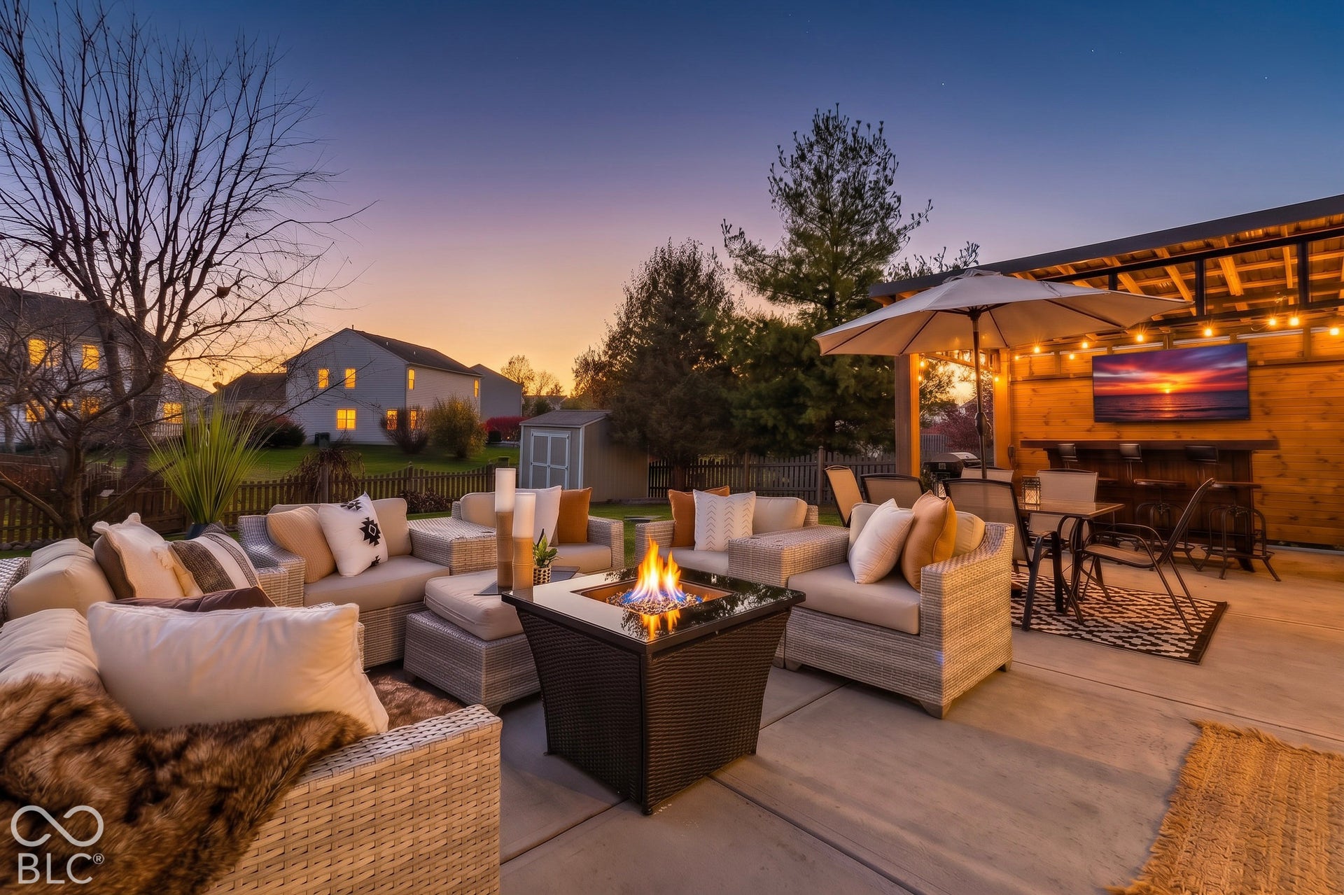 Enjoy peaceful evenings in this inviting outdoor living space, thoughtfully designed for relaxing and entertaining. A spacious covered patio features comfortable seating, a stylish outdoor bar, mounted television, dining area, and warm accent lightin