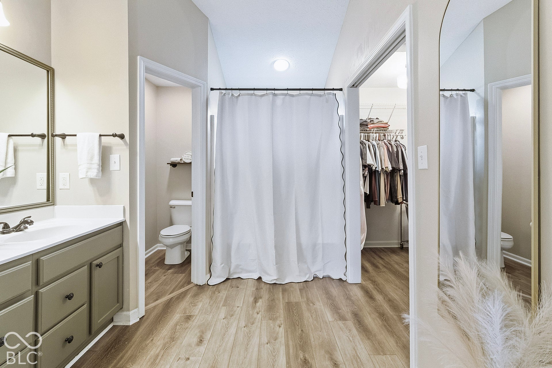 Beautifully updated primary bath featuring a spacious vanity with ample storage, oversized mirror, and stylish flooring.