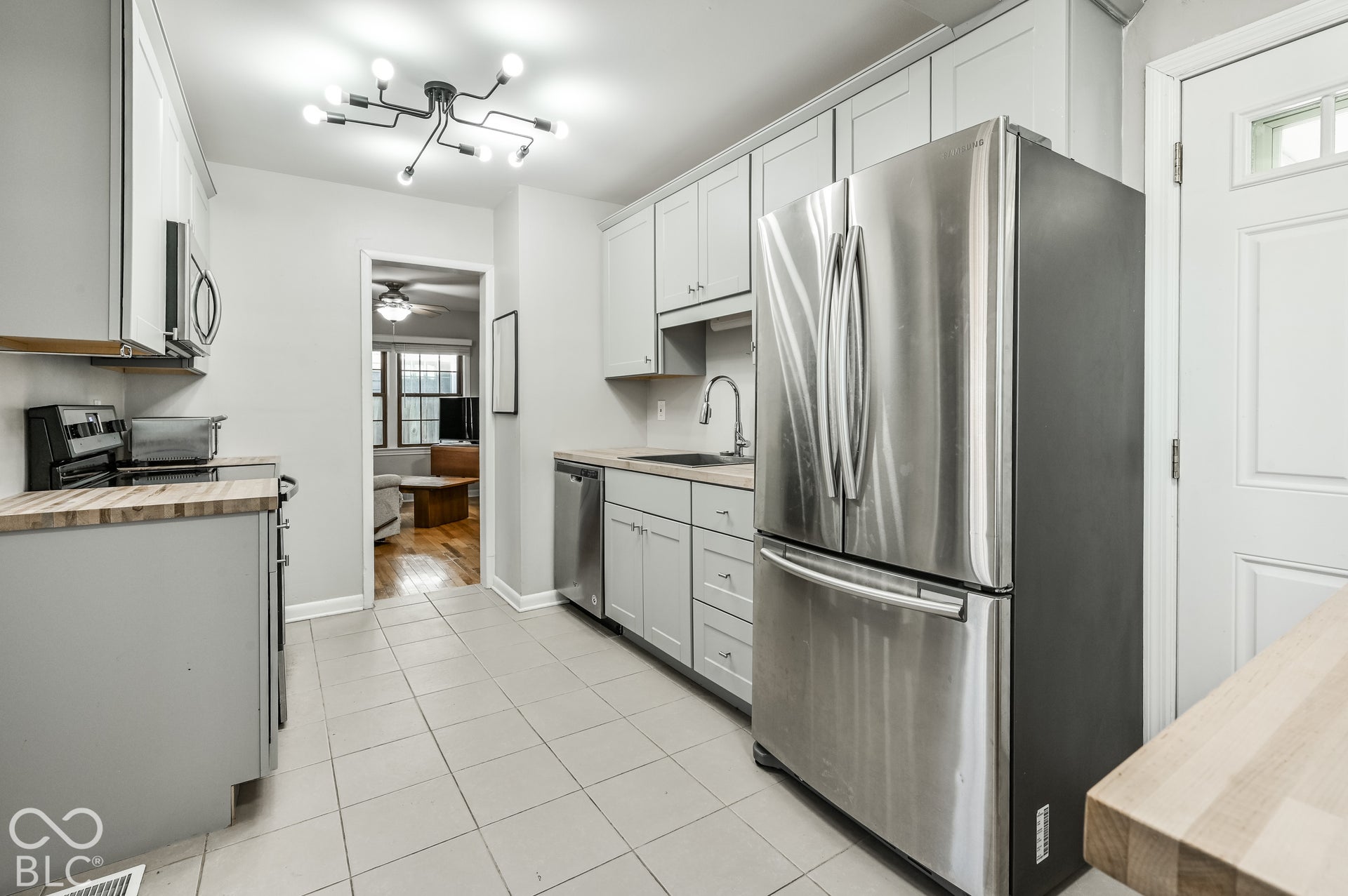 Stanless Steel appliances with a tile floor.