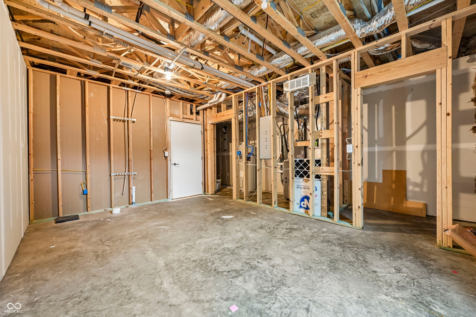 Unfinished basement with exposed wood framing, concrete flooring, and visible utility lines