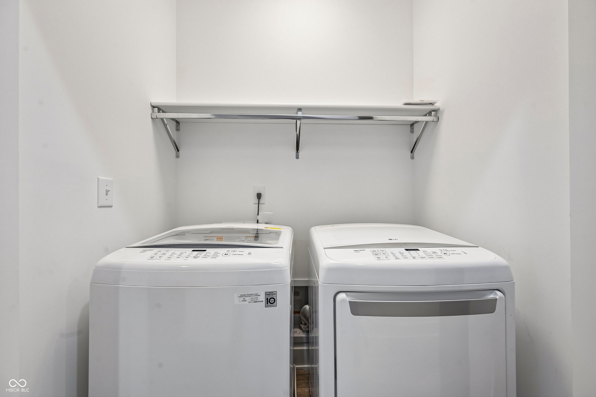 Dedicated laundry area featuring white walls and a white upper shelf with a chrome hanging rod