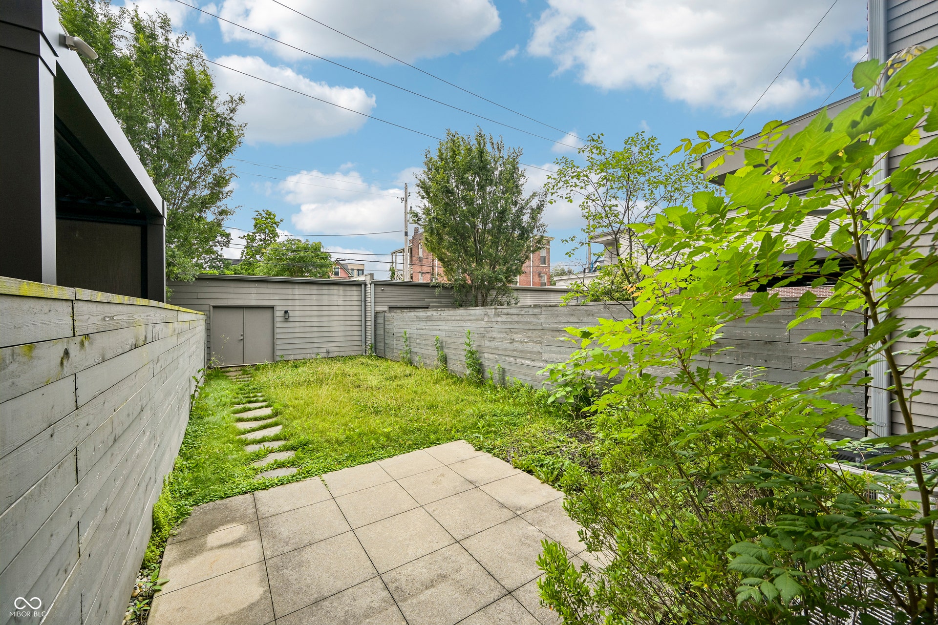 Private outdoor area featuring a paver patio, a stepping stone path, and a grass lawn