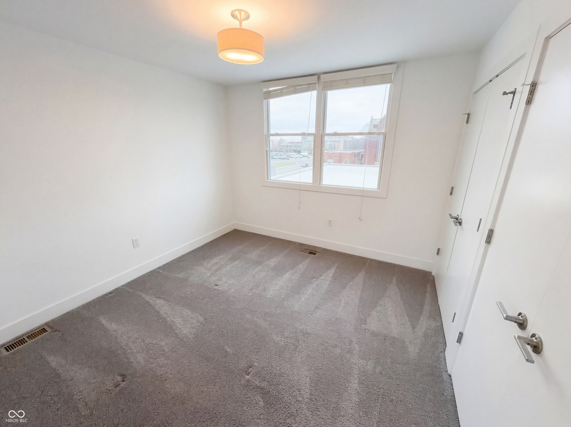 Neutral gray carpeting contrasts with crisp white walls and trim