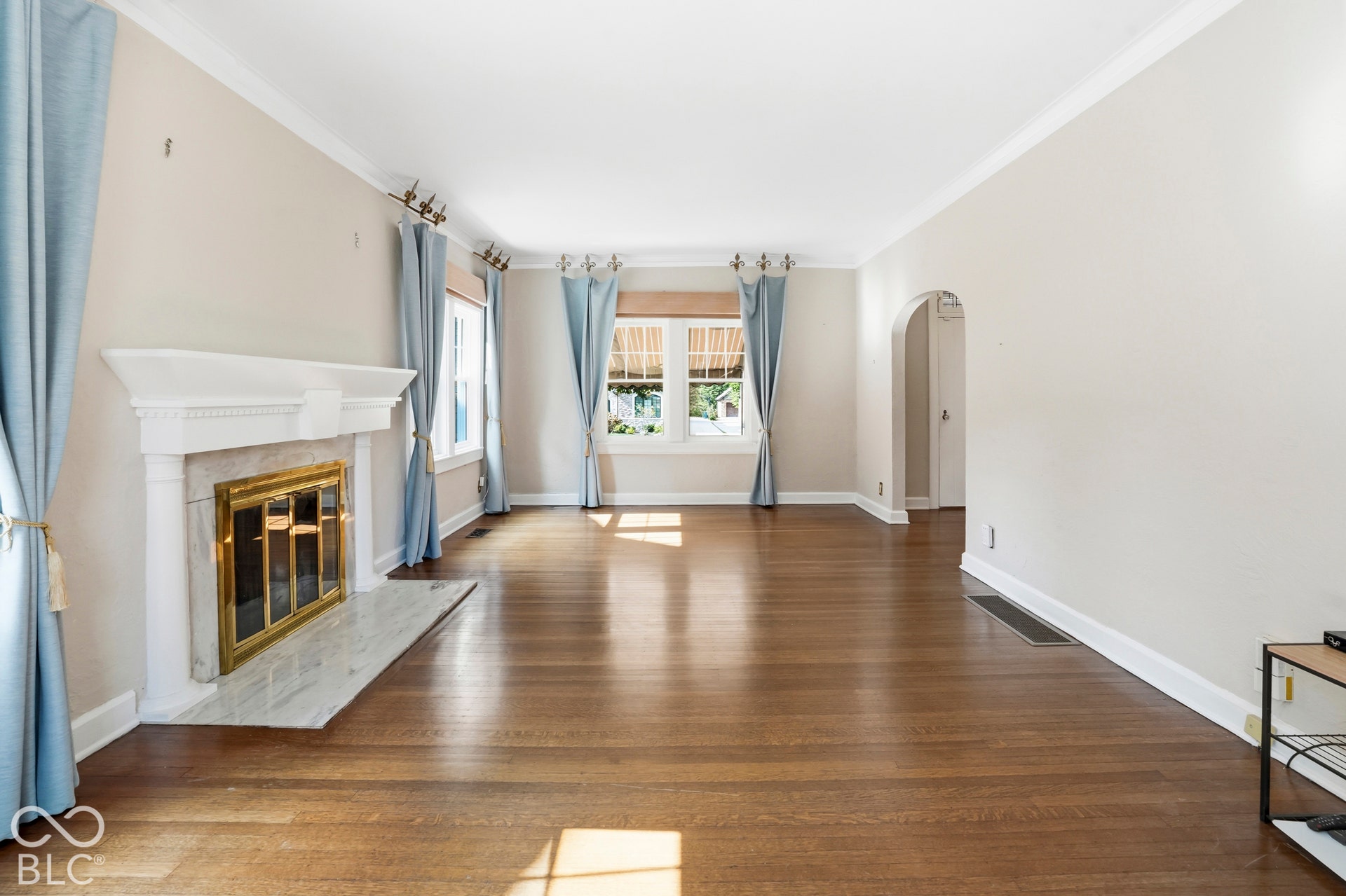 Sunny living room with wood burning fireplace and hardwood floors