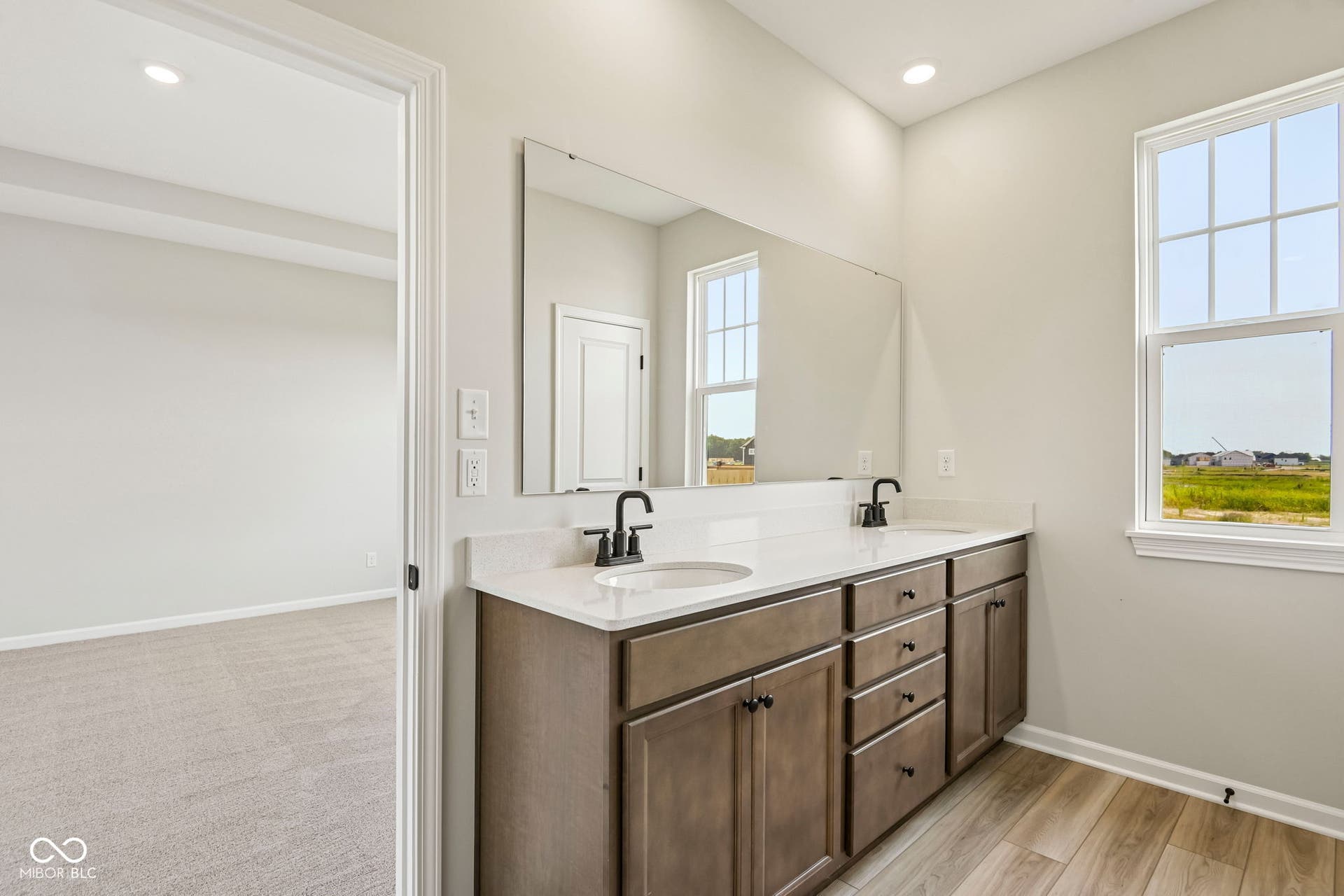 15691 Showdown Road, Noblesville, IN 46060 Bathroom vanity featuring dual undermount sinks, a quartz countertop, and dark-finished cabinetry with matte black hardware