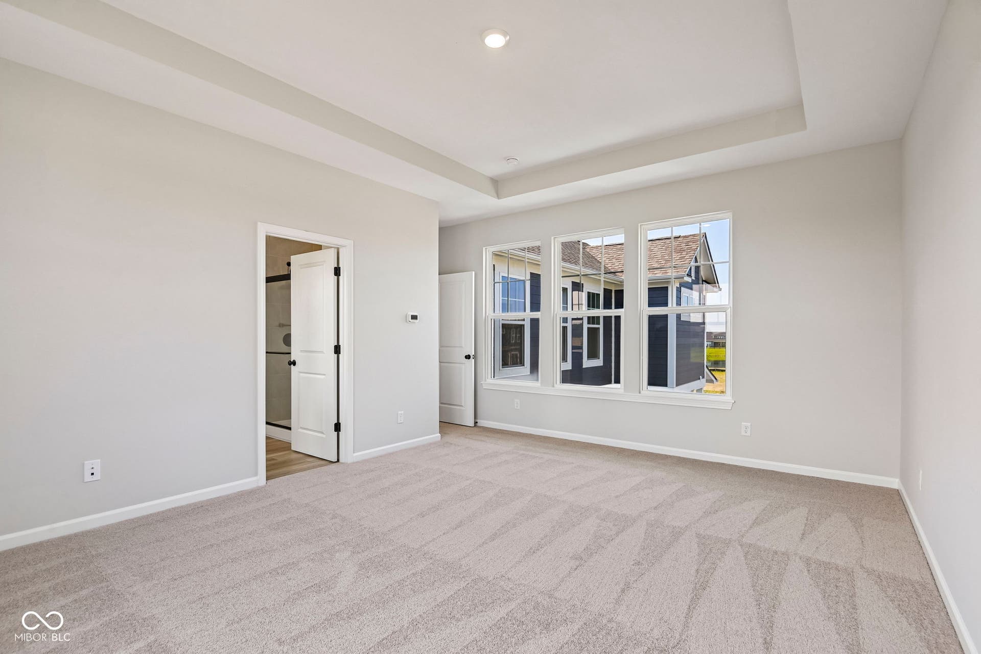 15691 Showdown Road, Noblesville, IN 46060 Spacious room featuring a tray ceiling, light gray wall tones, and neutral-toned patterned carpeting