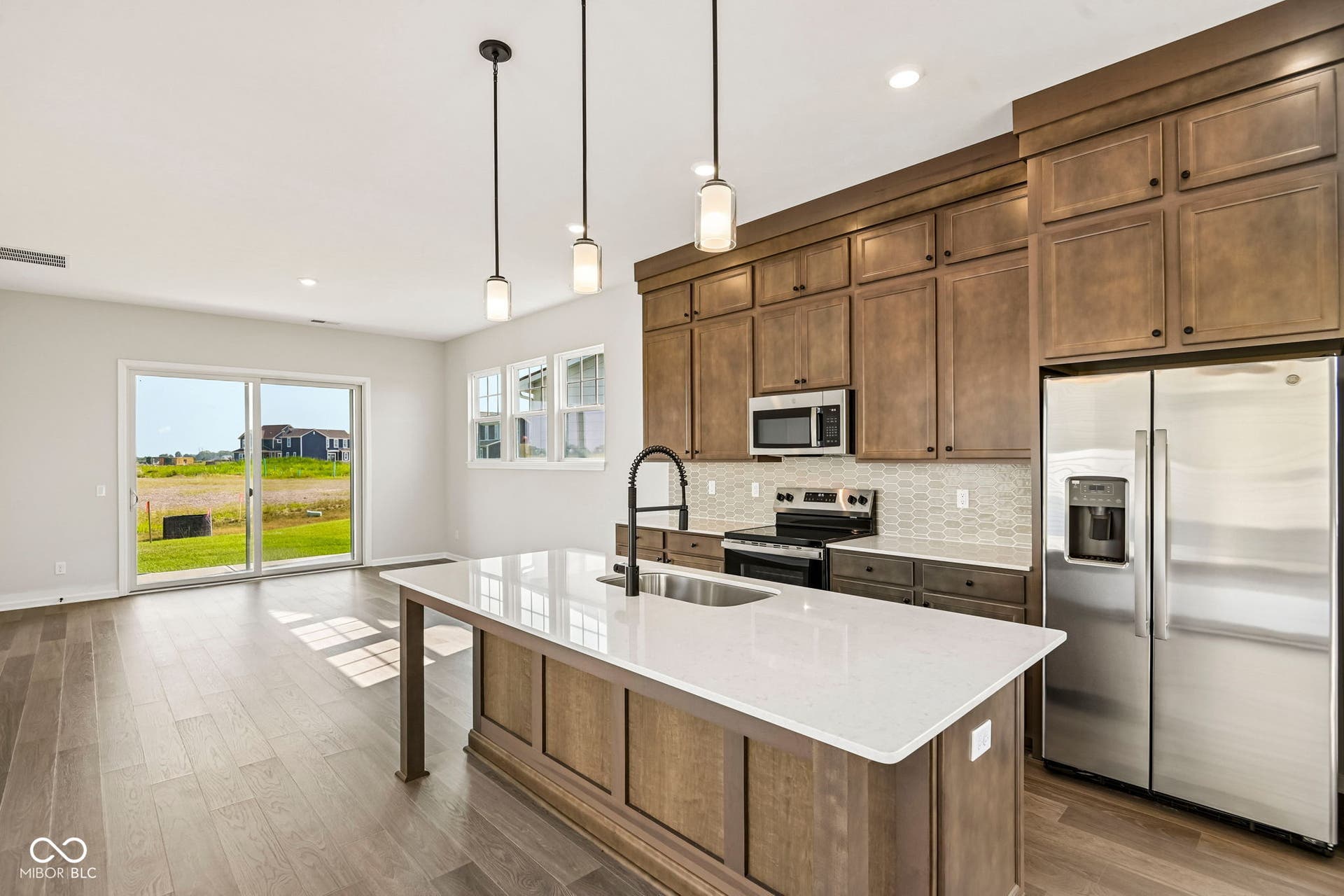 15691 Showdown Road, Noblesville, IN 46060 Modern kitchen featuring a large island with white countertop, dark wood-finish cabinetry, stainless steel appliances, and wood-finish flooring