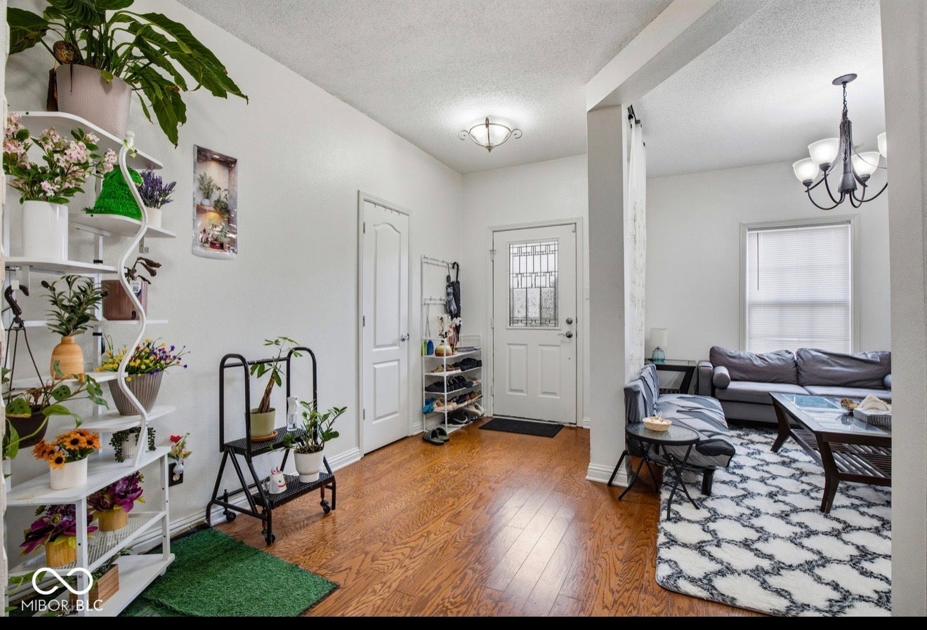 344 Legacy Boulevard, Greenwood, IN 46143 foyer with wood finished floors, a textured ceiling, and a chandelier