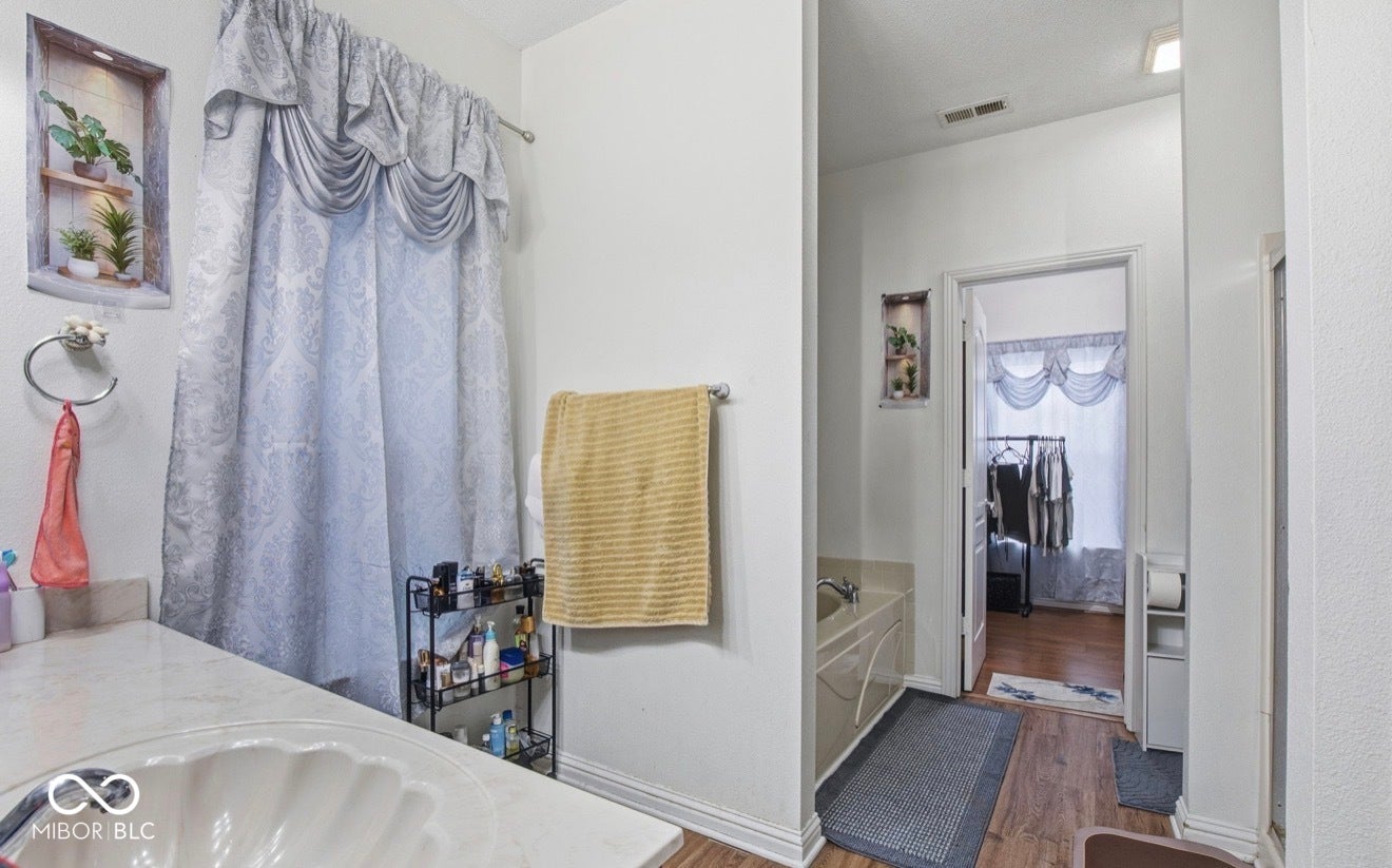 344 Legacy Boulevard, Greenwood, IN 46143 bathroom with vanity, wood finished floors, and a garden tub