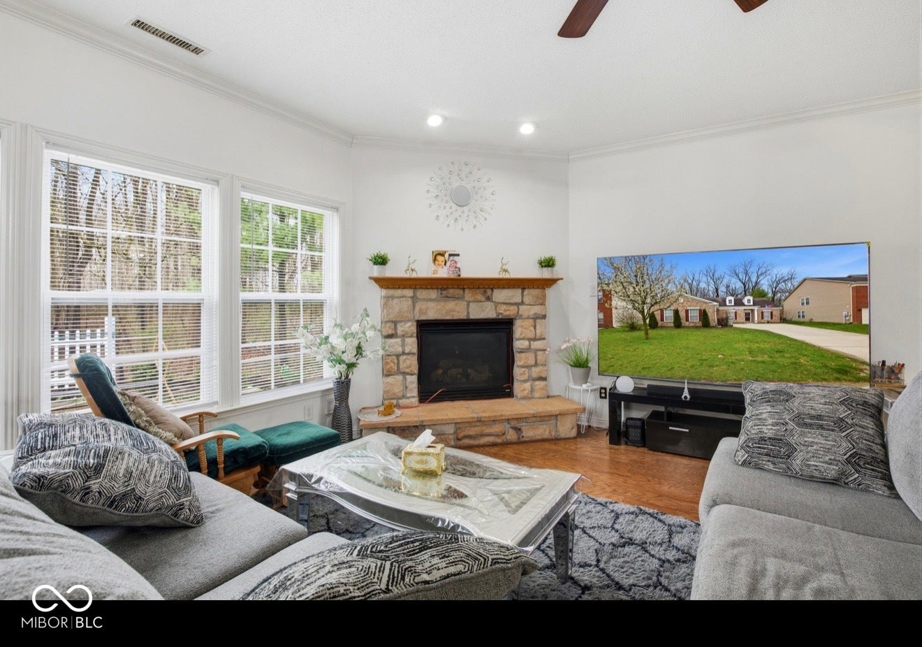 344 Legacy Boulevard, Greenwood, IN 46143 living room with a ceiling fan, wood finished floors, a fireplace, and ornamental molding