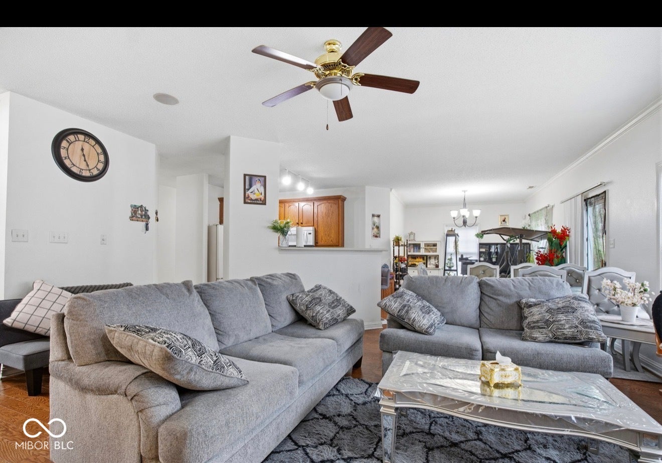 344 Legacy Boulevard, Greenwood, IN 46143 living area with a ceiling fan, hanging lights, and wood finished floors
