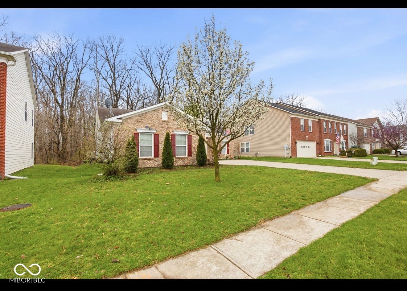 344 Legacy Boulevard, Greenwood, IN 46143 view of front of house featuring brick siding, a front lawn, driveway, and an attached garage