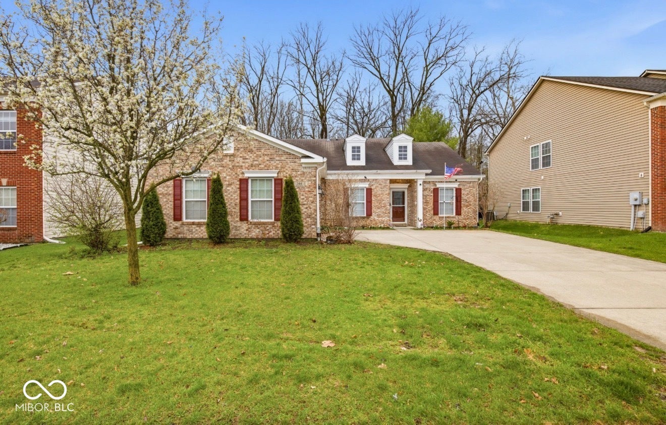 344 Legacy Boulevard, Greenwood, IN 46143 cape cod-style house featuring a front yard, brick siding, concrete driveway, and a porch