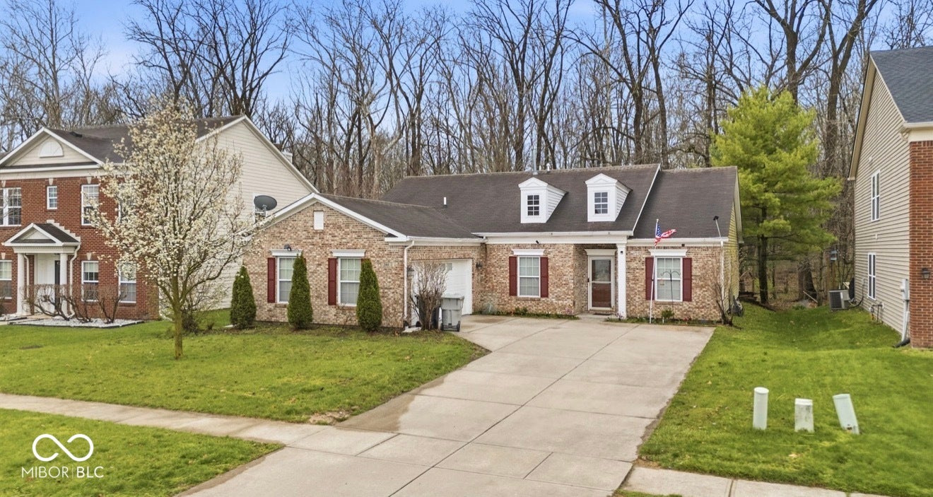 344 Legacy Boulevard, Greenwood, IN 46143 view of front of home featuring driveway, a front yard, brick siding, and roof with shingles