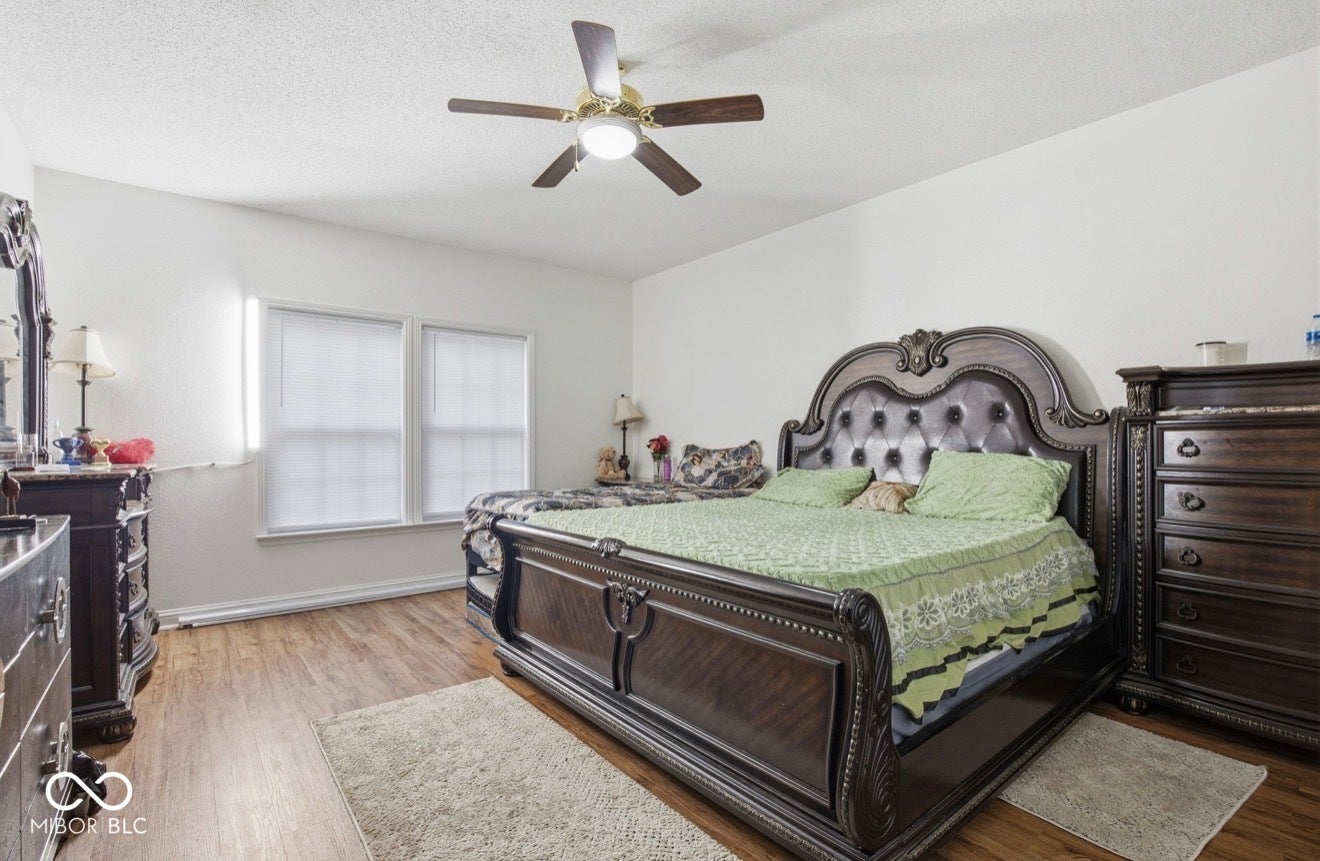 344 Legacy Boulevard, Greenwood, IN 46143 bedroom featuring light wood-type flooring, ceiling fan, and a textured ceiling
