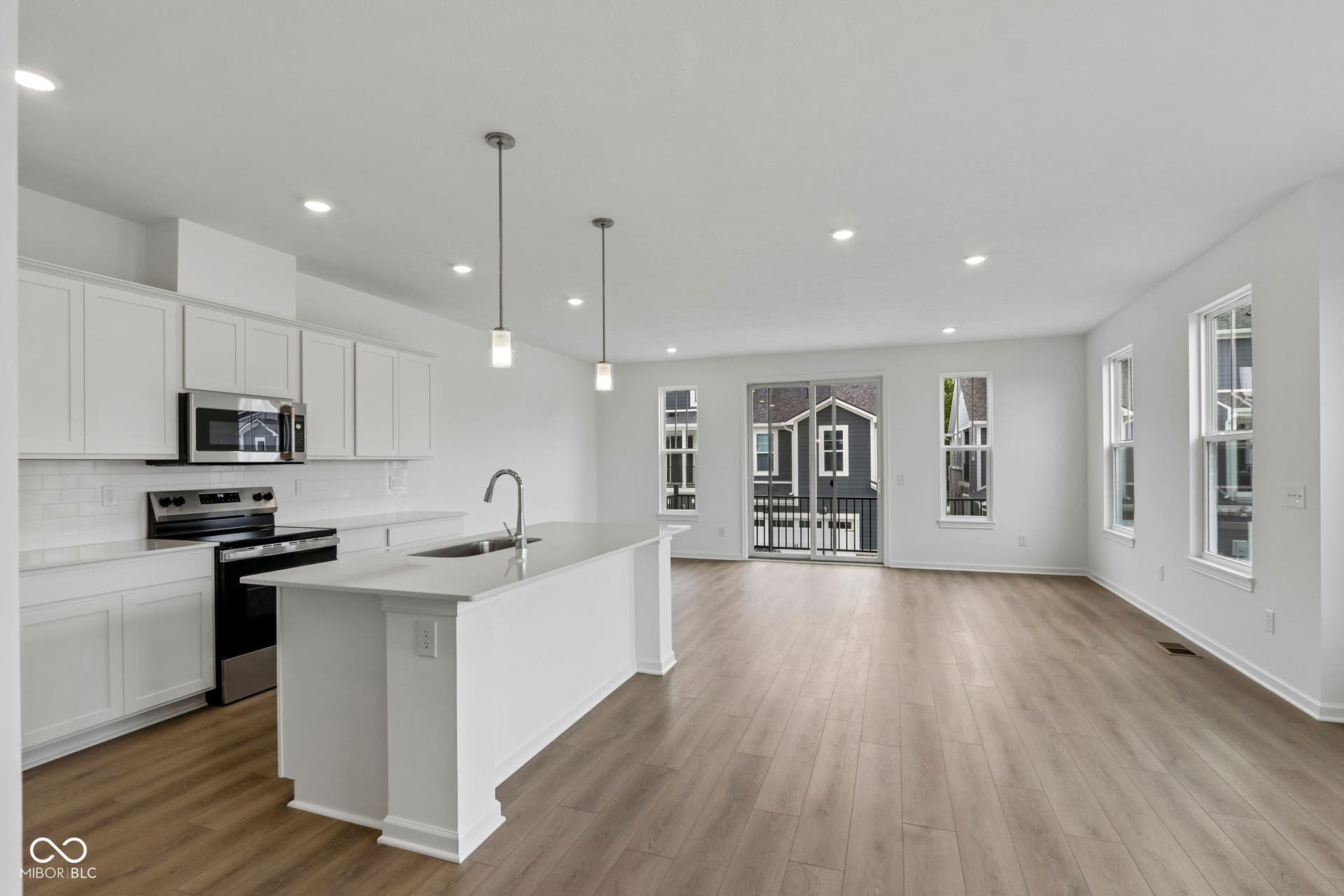 5748 Arcade Boulevard, McCordsville, IN 46055 Open-concept living space featuring a central kitchen island with a sink and pendant lighting