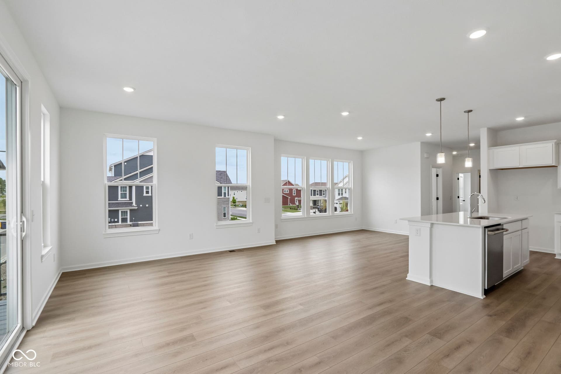 5748 Arcade Boulevard, McCordsville, IN 46055 Open-concept living area featuring wood-finish flooring, recessed lighting, and a sliding glass door