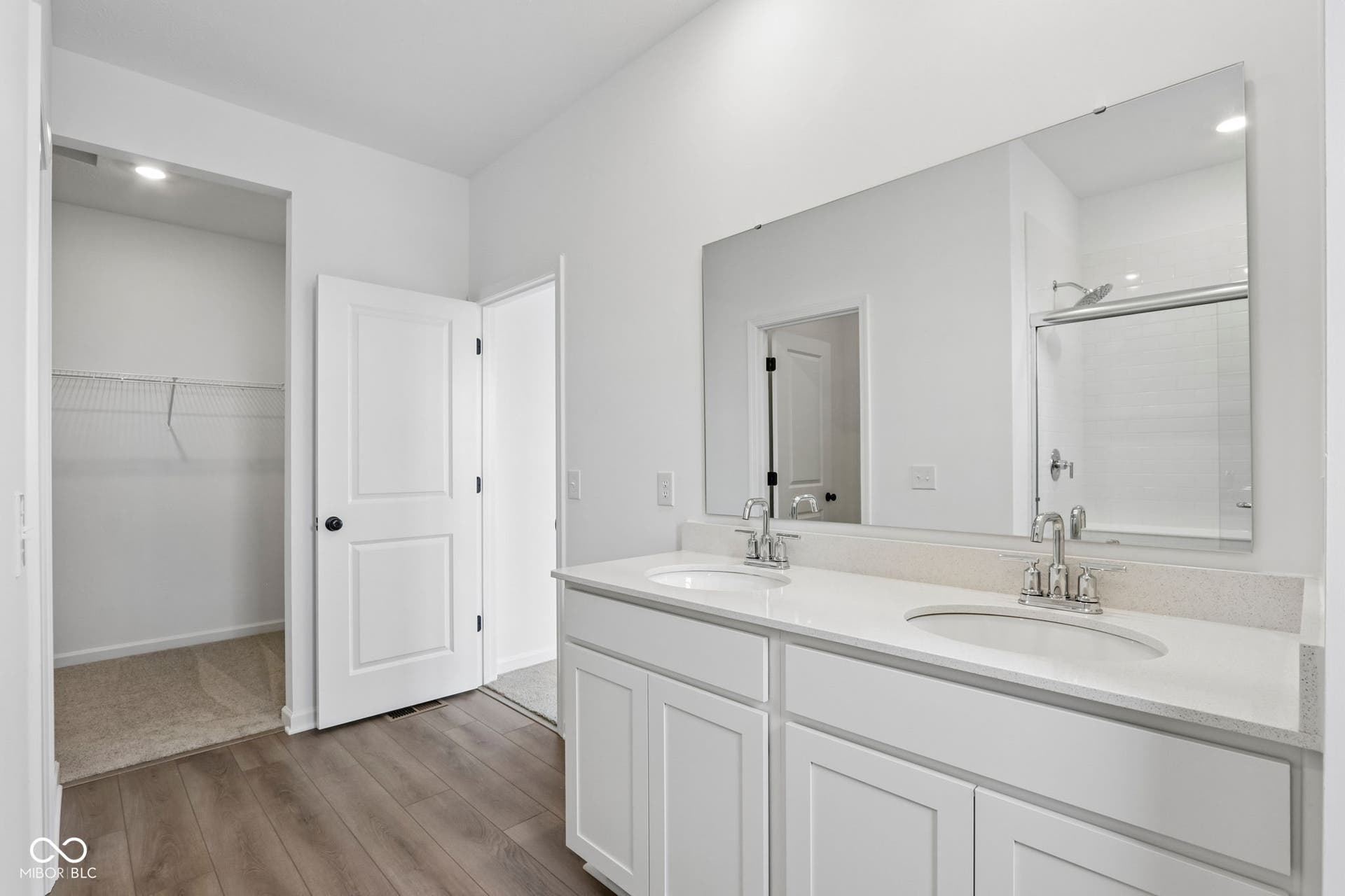 5748 Arcade Boulevard, McCordsville, IN 46055 Bathroom featuring a double vanity with stone-finish countertop, undermount sinks, and a frameless mirror