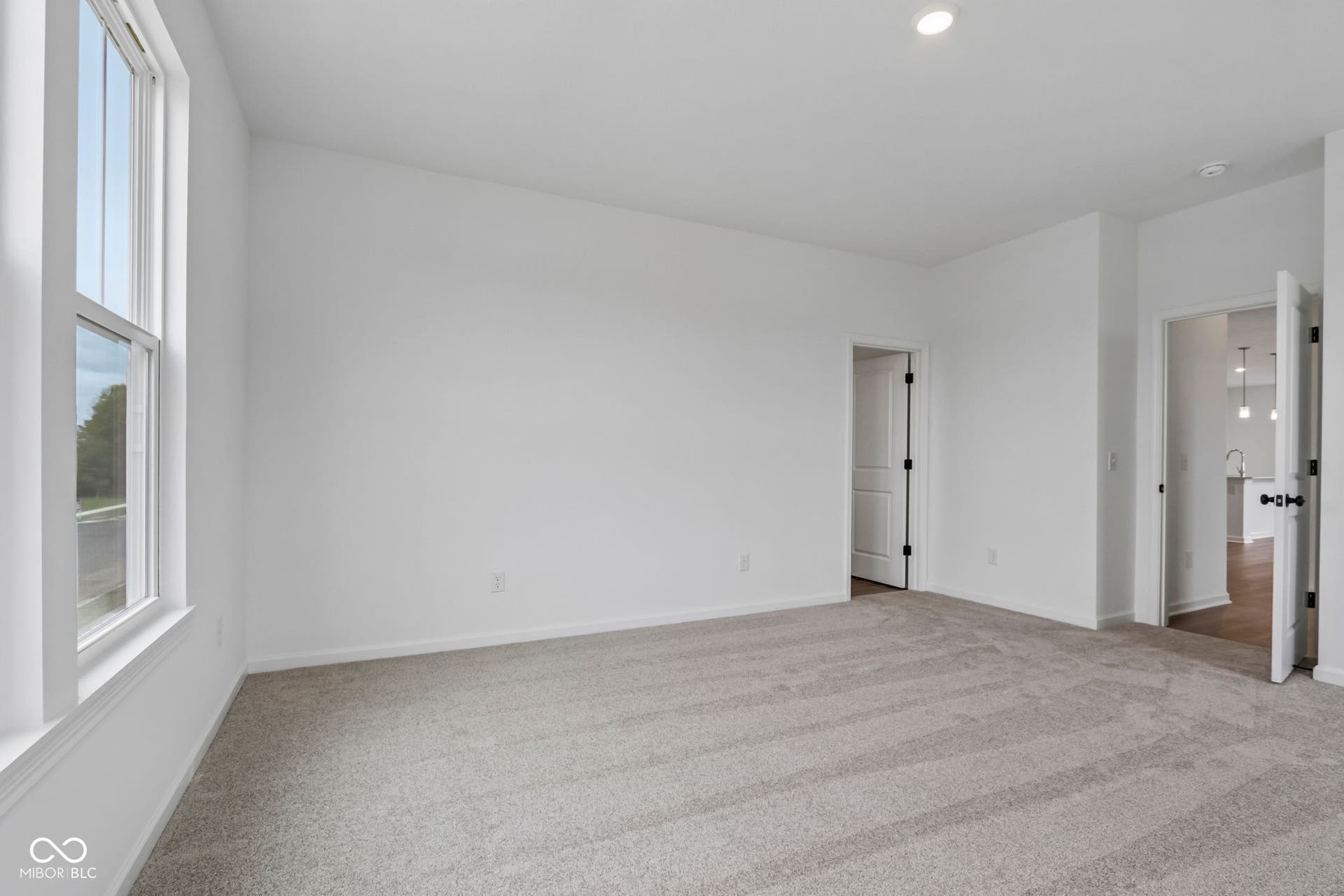 5748 Arcade Boulevard, McCordsville, IN 46055 Spacious room featuring neutral carpeting, a large window, white walls, recessed lighting, and two interior doors with dark hardware