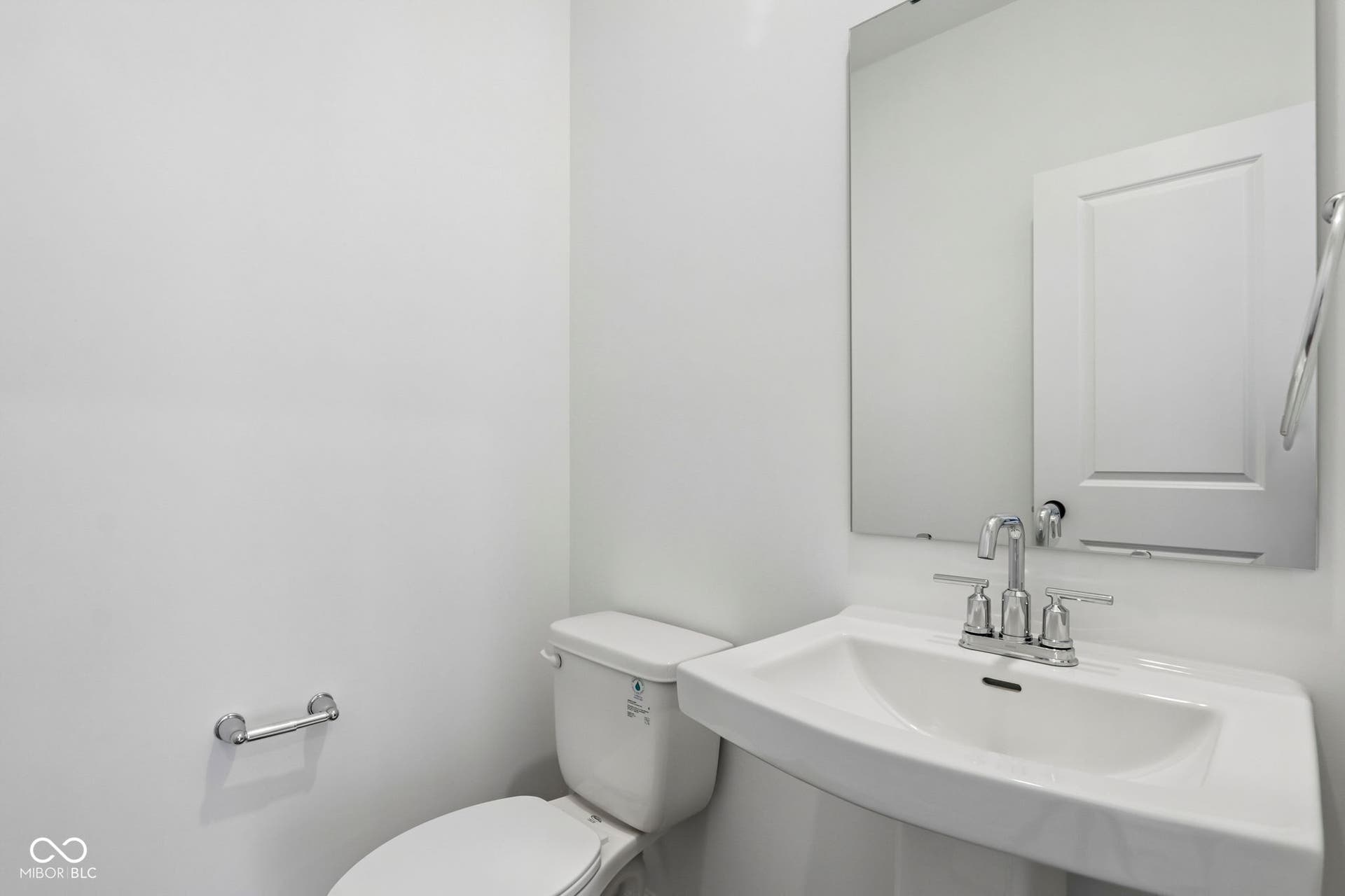 5748 Arcade Boulevard, McCordsville, IN 46055 Pedestal sink with chrome faucet, large wall-mounted mirror, and white toilet
