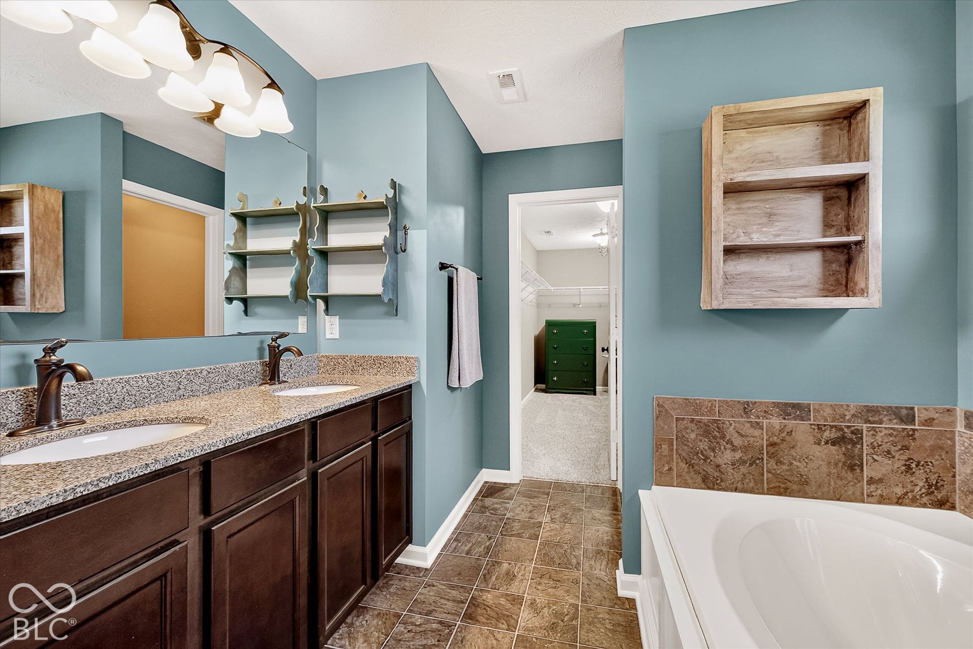 Primary en-suite with garden tub, dual sinks, separate shower, and access to the walk-in-closet