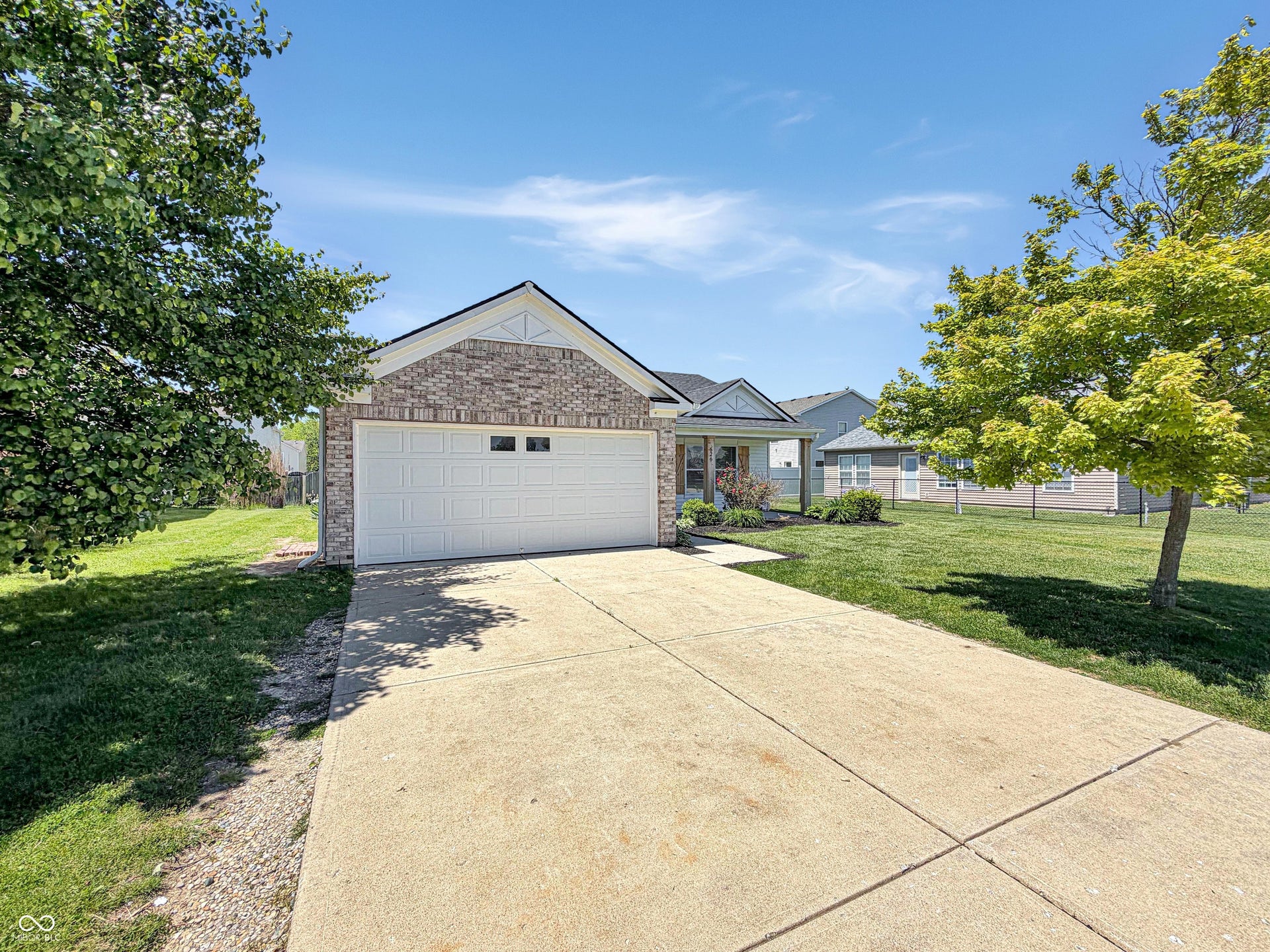 526 Bourneside Drive, Greenfield, IN 46140 Brick and siding exterior featuring an attached two-car garage with a concrete driveway and sidewalk
