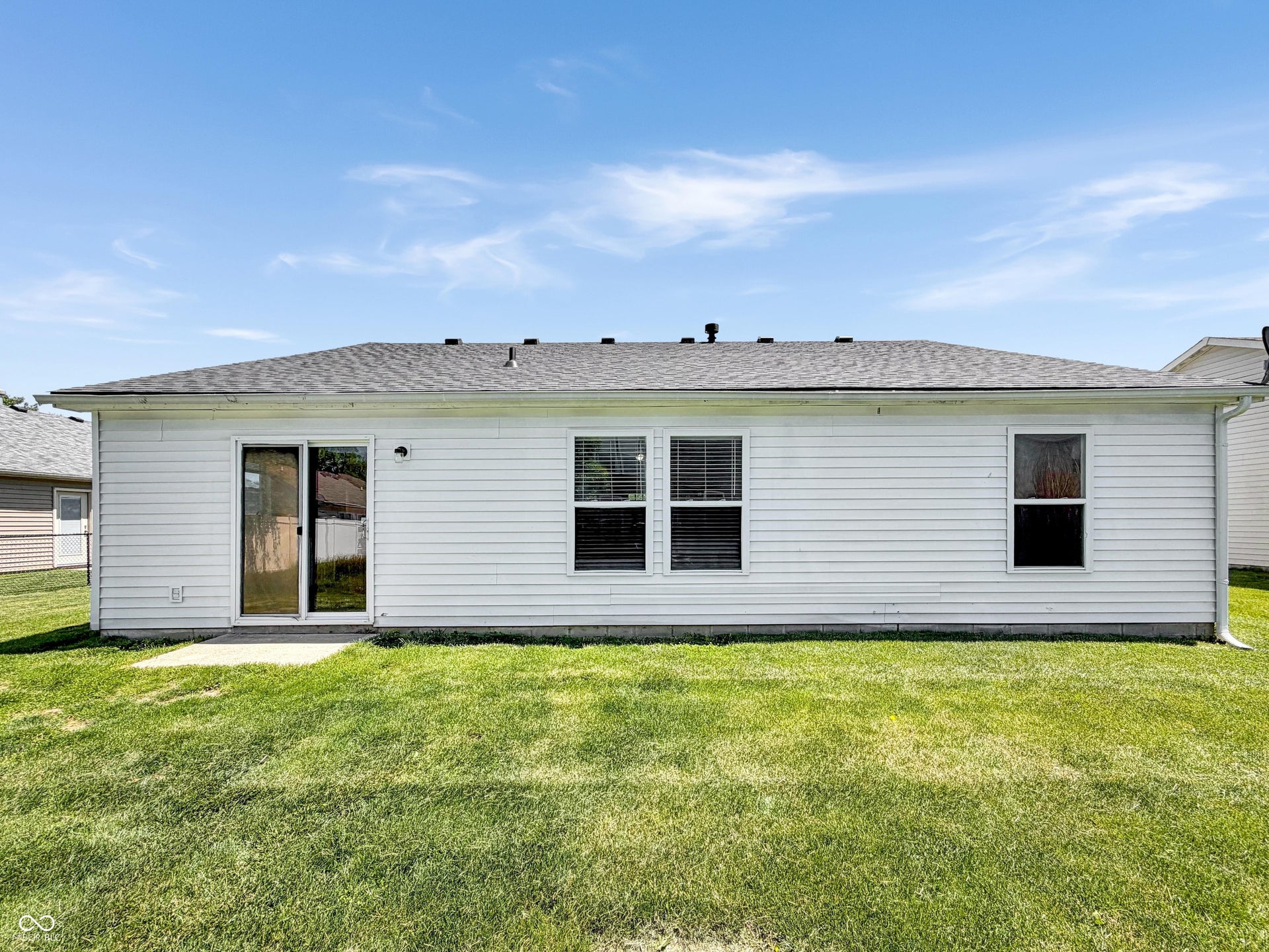 526 Bourneside Drive, Greenfield, IN 46140 Rear exterior featuring white horizontal siding, a gray shingle roof, a concrete patio, and a sliding glass door