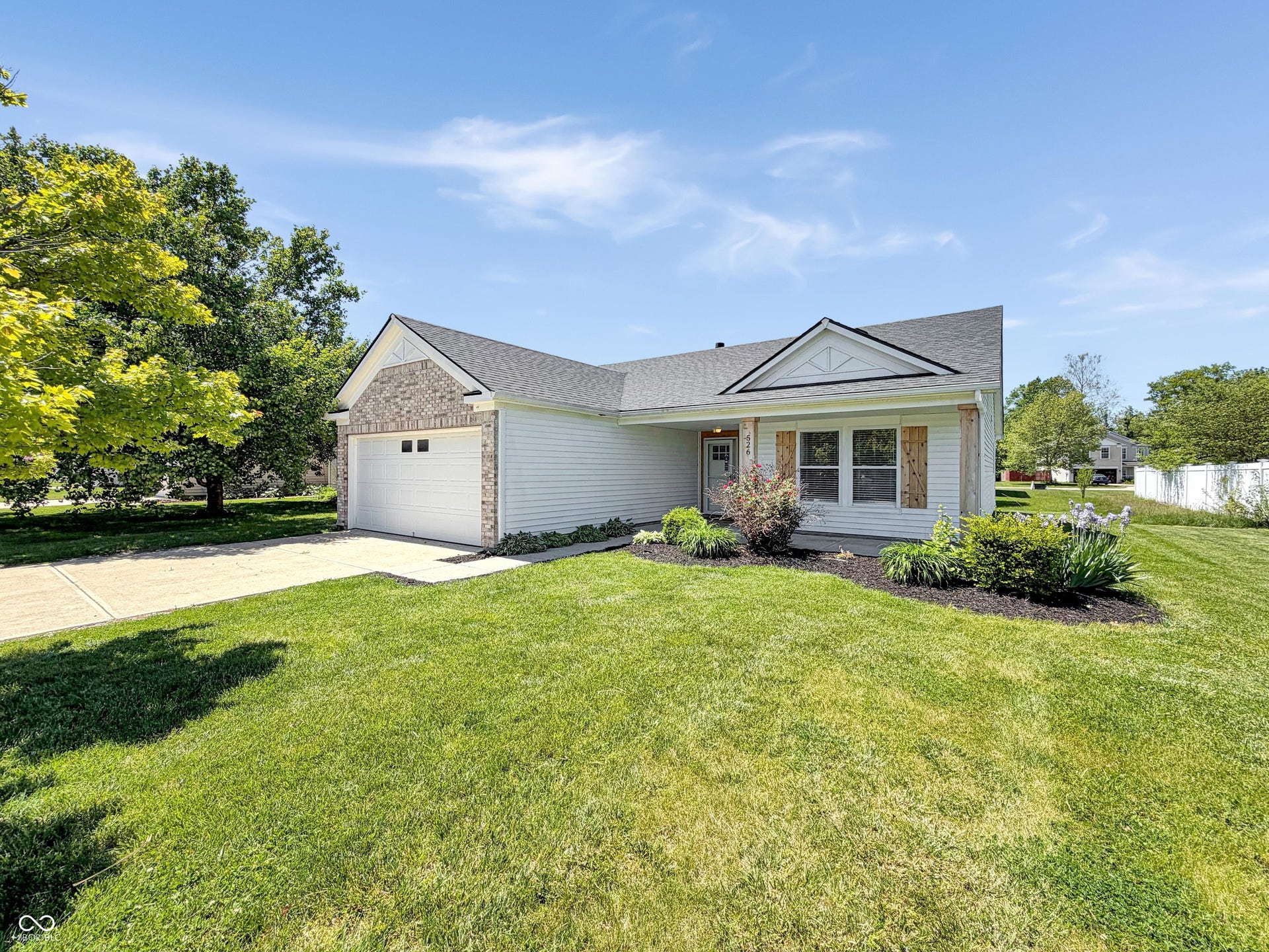526 Bourneside Drive, Greenfield, IN 46140 Single-story residence featuring light-colored siding, a prominent attached garage with a white door, and a concrete driveway