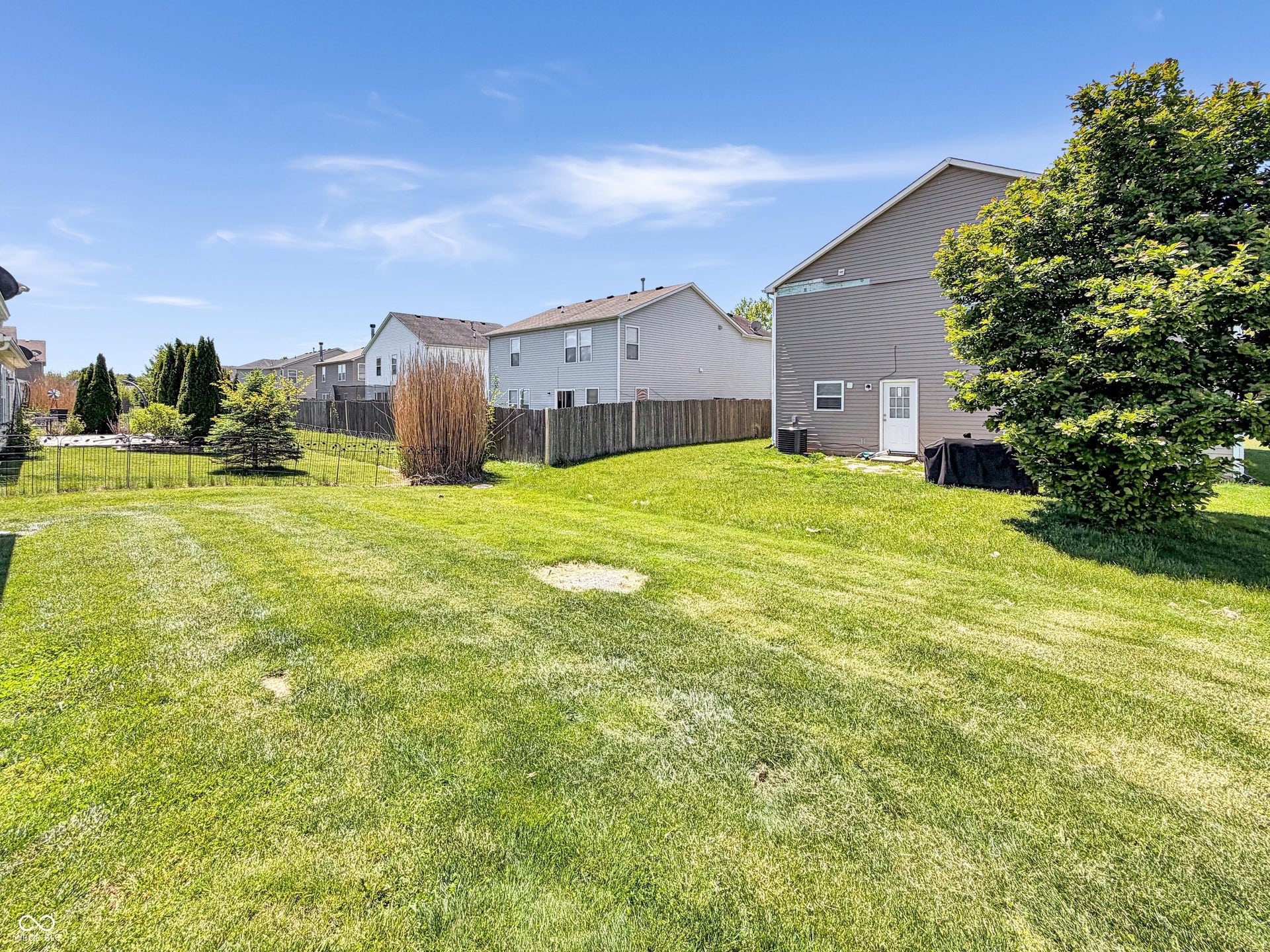 526 Bourneside Drive, Greenfield, IN 46140 Expansive green lawn with mature trees and perimeter fencing