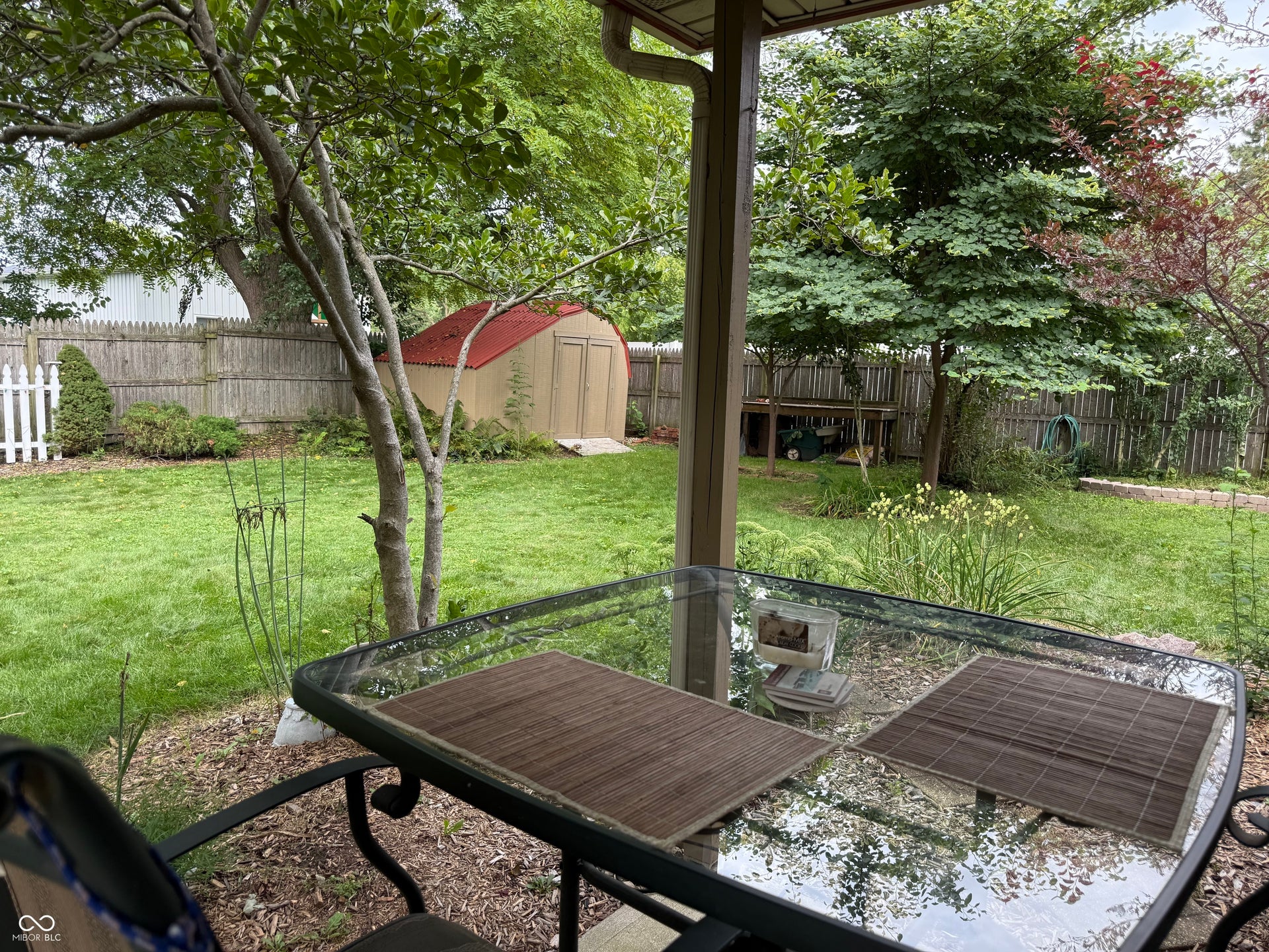 2117 Witt Road, Lebanon, IN 46052 Expansive backyard featuring a manicured lawn, established trees, and a wooden privacy fence