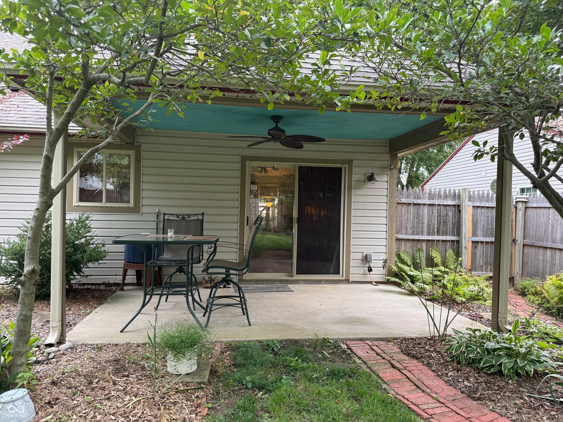2117 Witt Road, Lebanon, IN 46052 Covered patio featuring a ceiling fan, sliding glass door, and adjacent landscaping