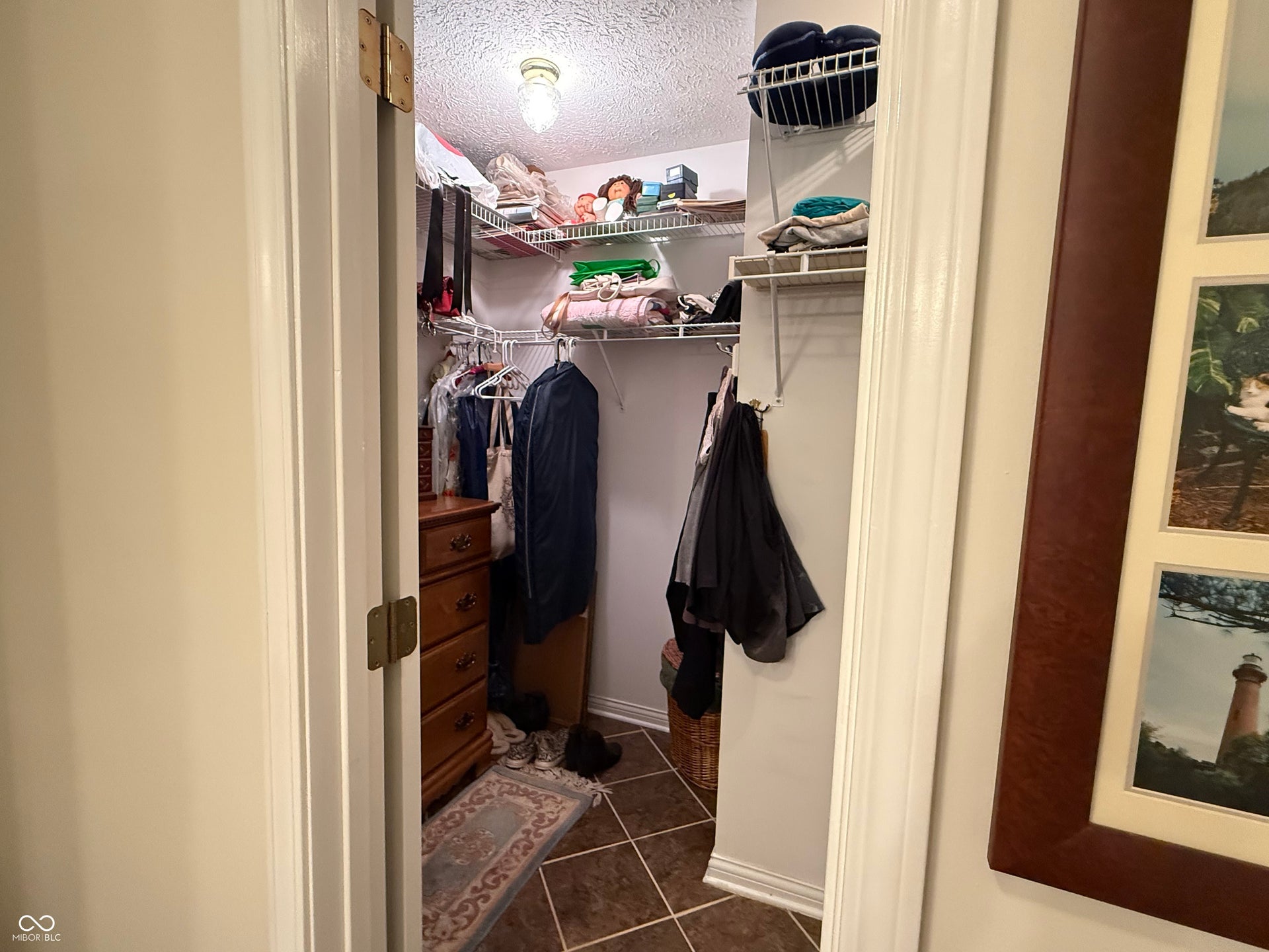 2117 Witt Road, Lebanon, IN 46052 Walk-in closet featuring wire shelving, hanging rods, and heated tile flooring in Primary Bathroom.