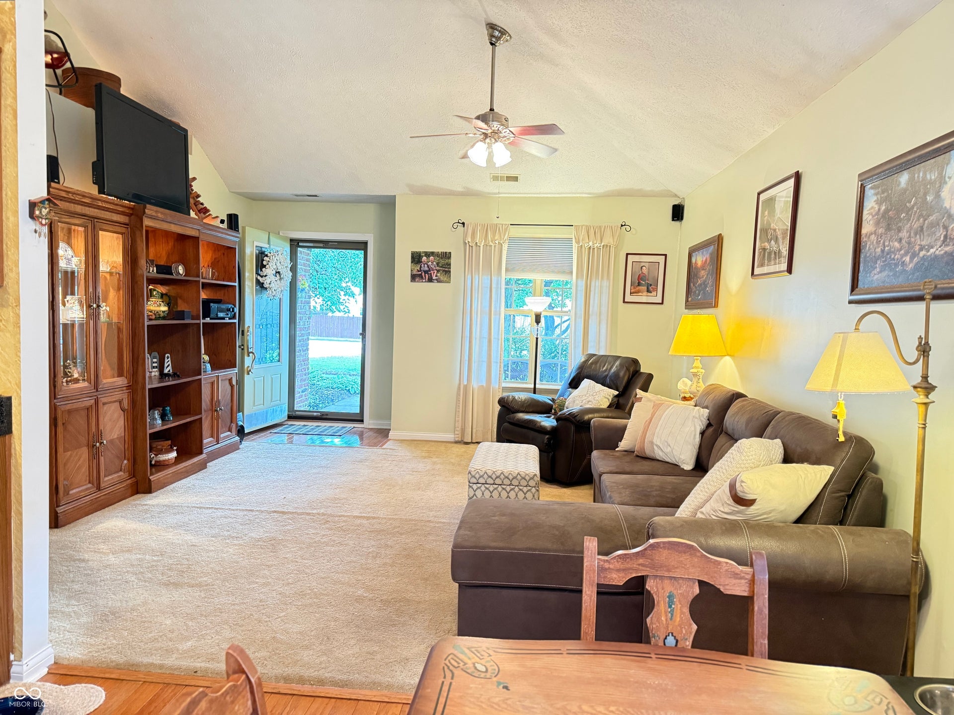 2117 Witt Road, Lebanon, IN 46052 Vaulted ceiling with a ceiling fan, carpet flooring, a front door with a glass insert, and a window with curtains