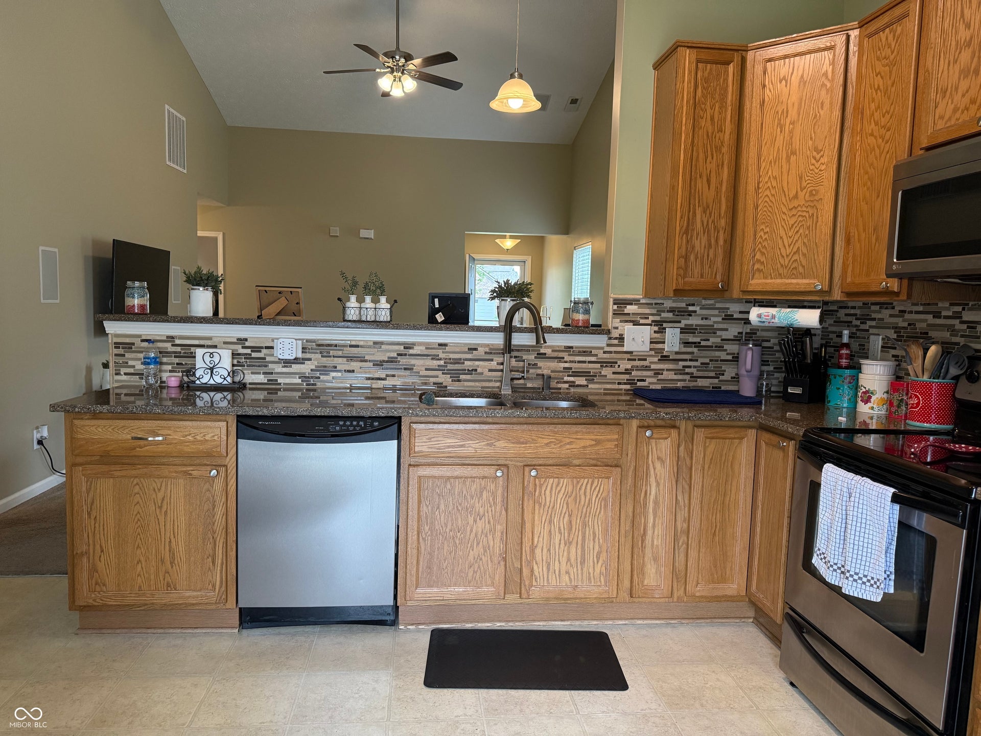 Kitchen featuring wood cabinetry, granite-finish countertops, and a mosaic tile backsplash