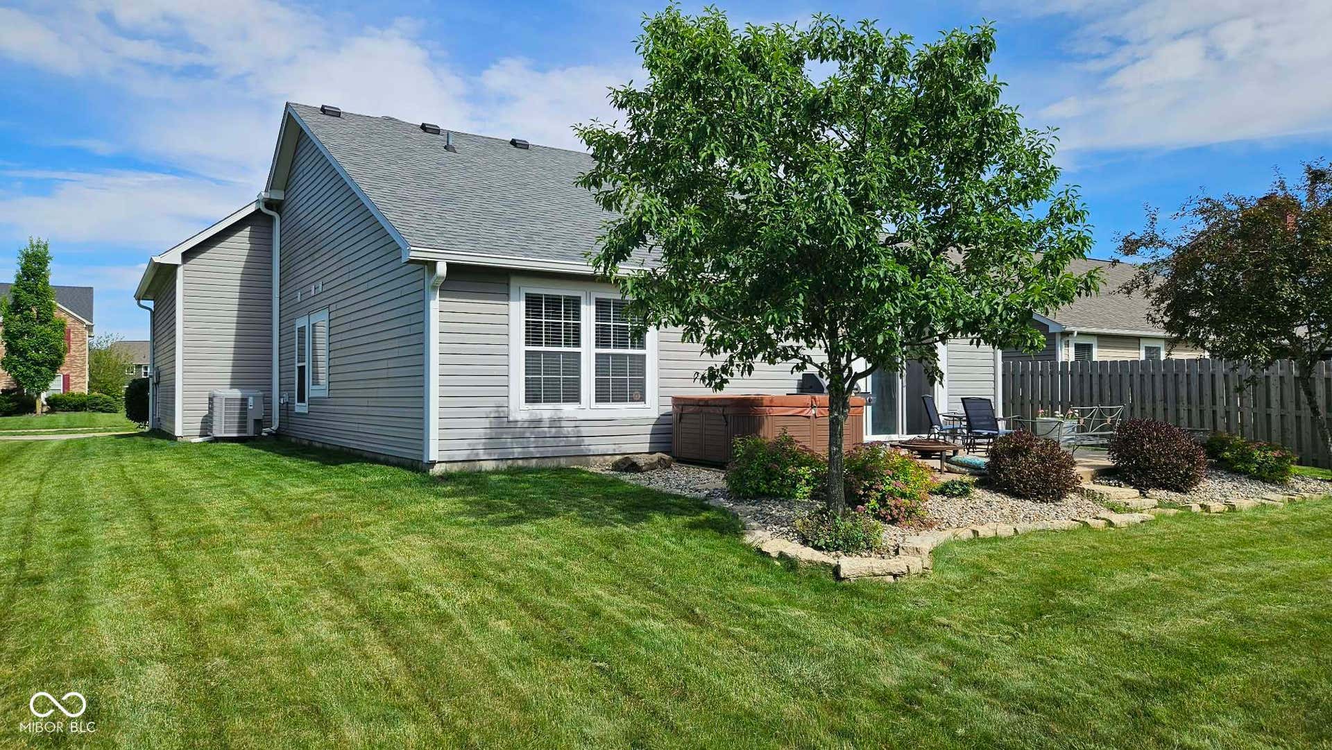 Gray siding exterior featuring multiple windows and a sliding glass door