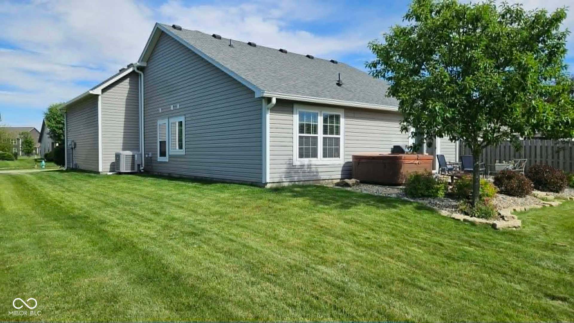 Spacious backyard featuring a manicured lawn, a concrete patio area.  Hot tub will be removed prior to closing.