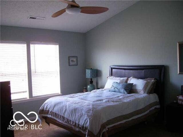 Bedroom featuring a vaulted ceiling and a ceiling fan with light fixture.
