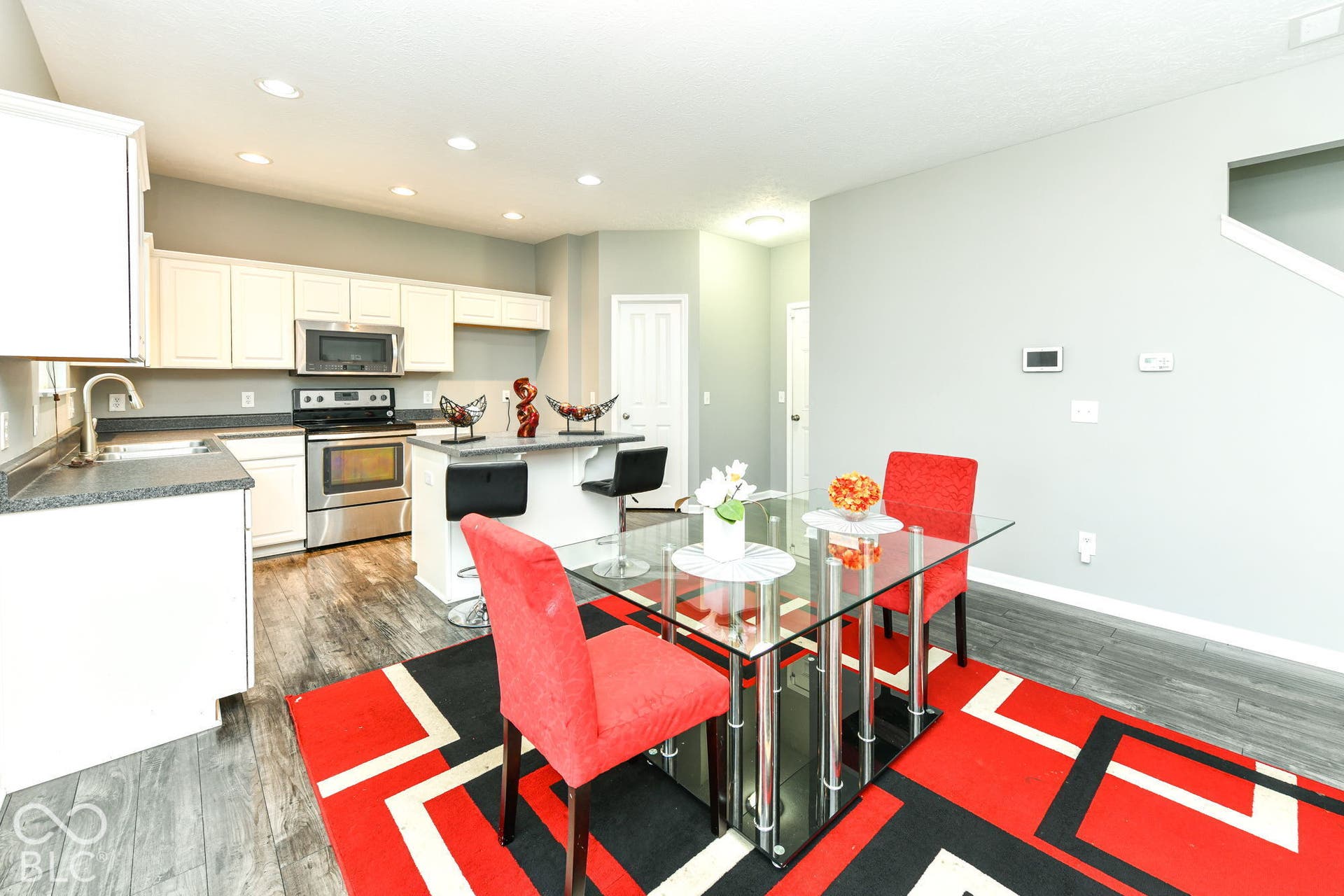 Kitchen with stainless steel appliances, light cabinetry, and dark countertops