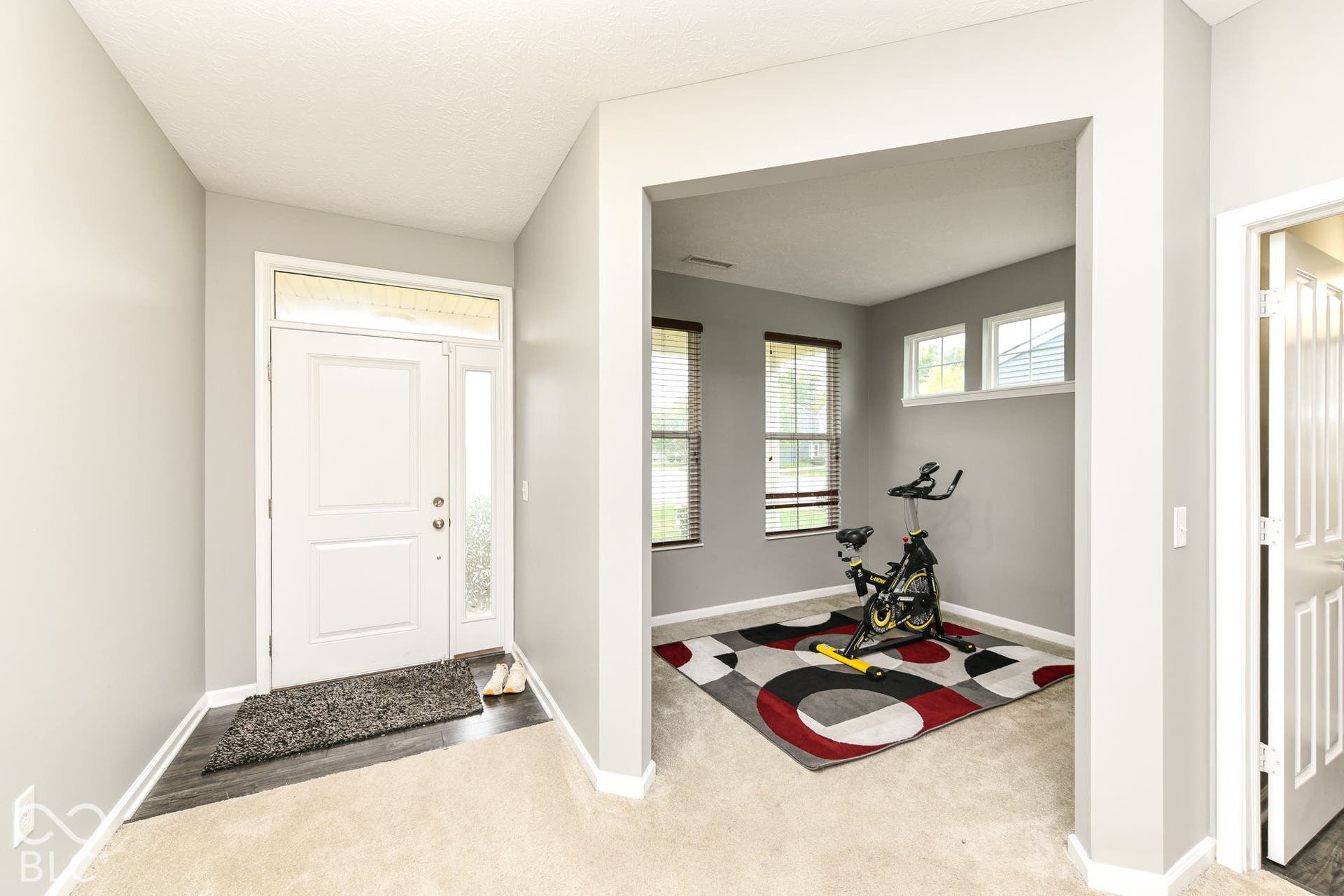 Entryway with a paneled white door, transom window, and sidelight