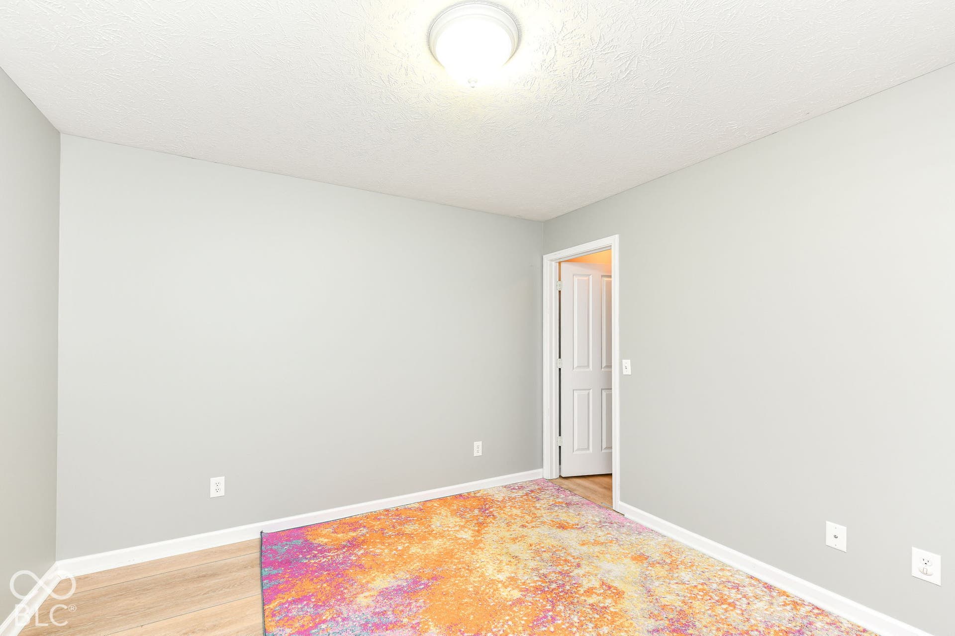 Light wood-finish flooring, light gray wall paint, and white trim