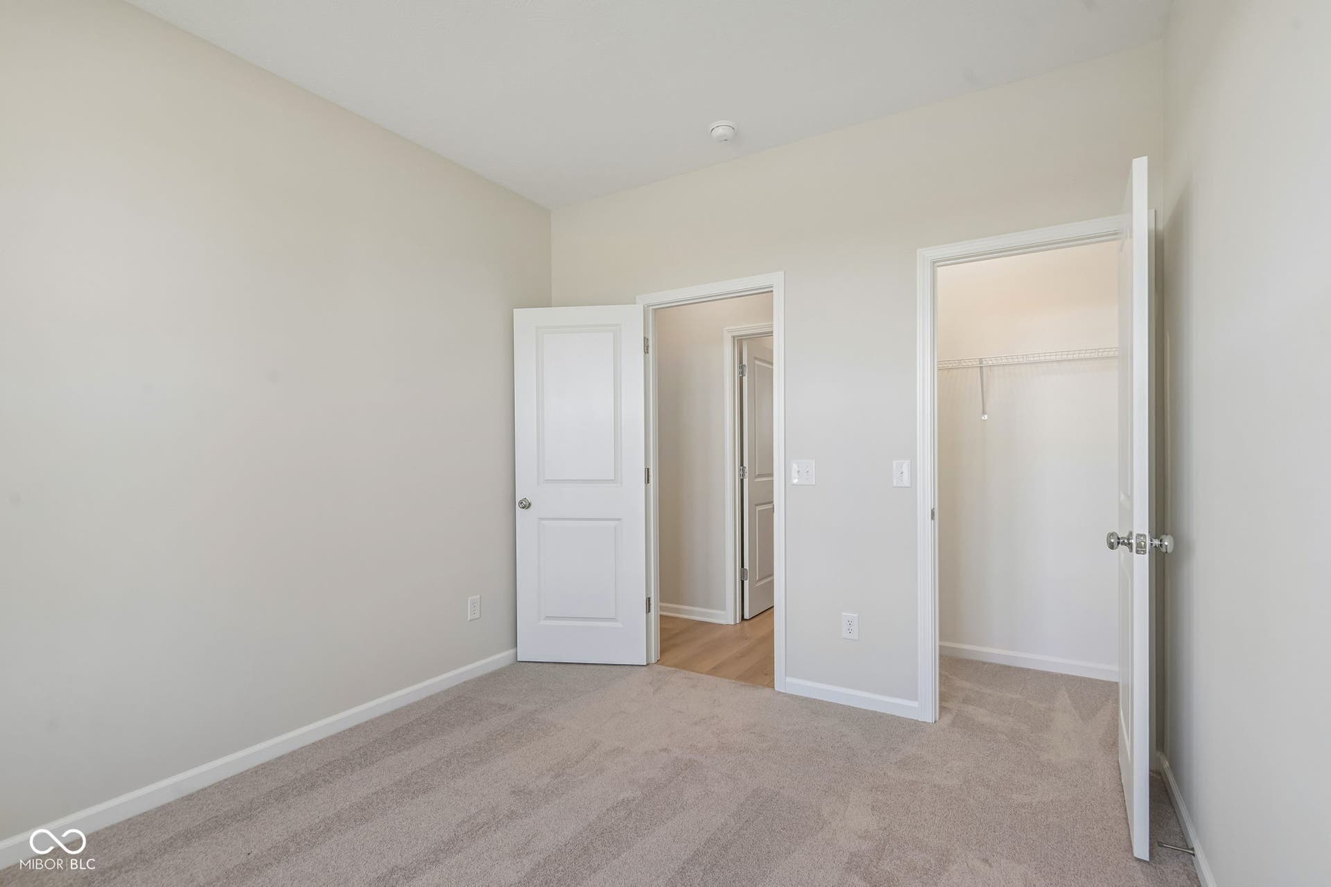 Neutral-toned carpeting and light wall paint create a bright atmosphere