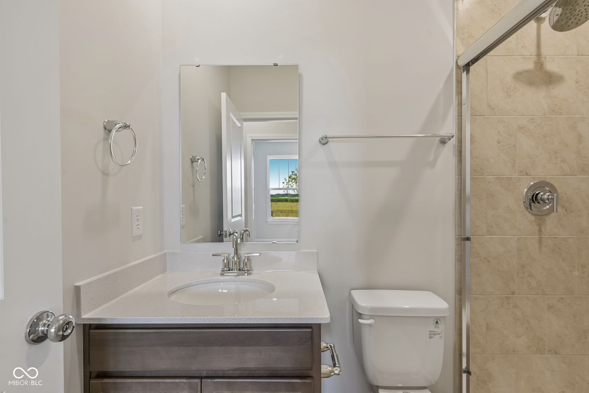 Bathroom featuring a single vanity with stone-finish countertop, undermount sink, and wood-finish cabinetry