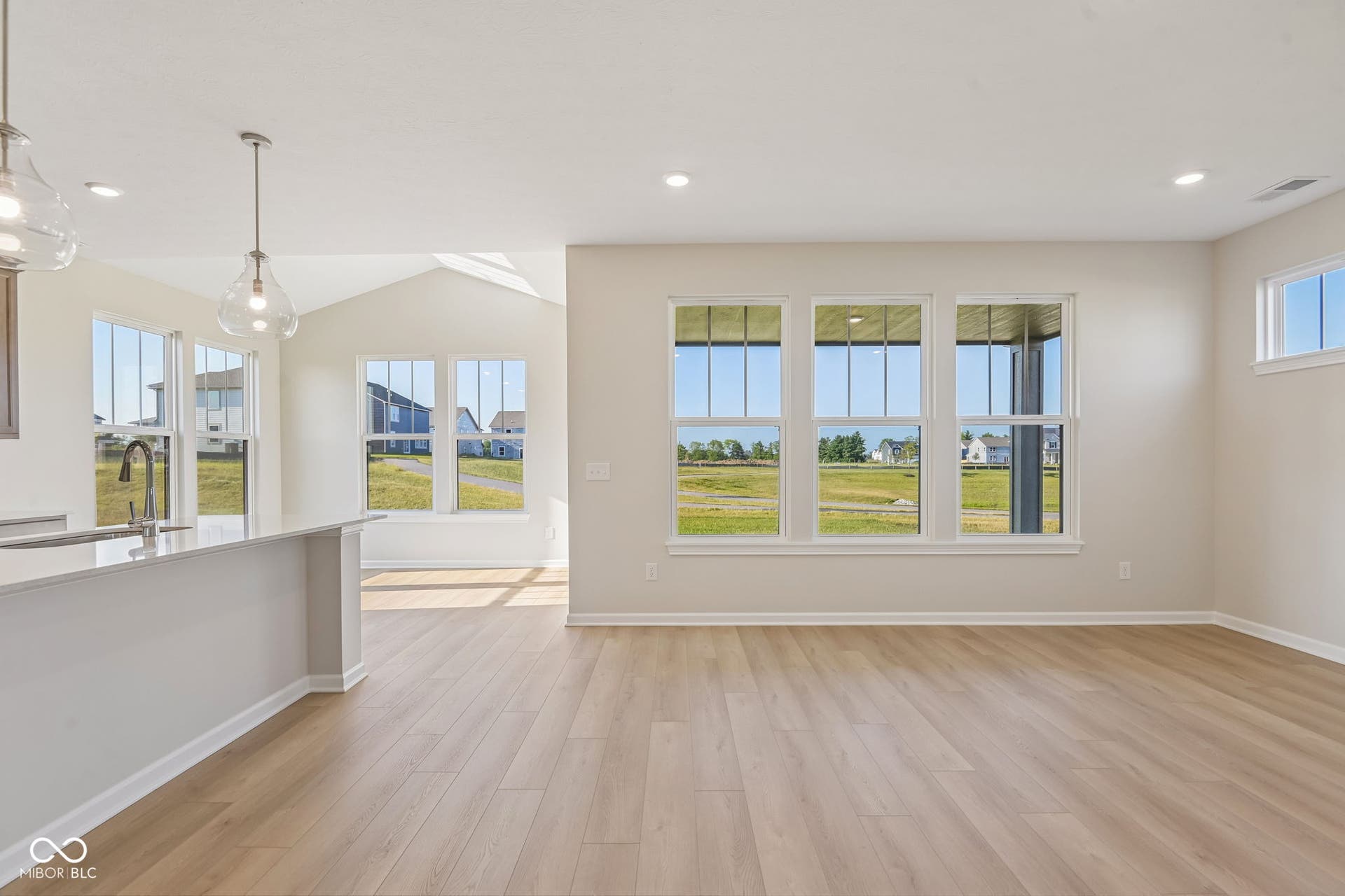 Spacious interior featuring wood-finish flooring, recessed lighting, and multiple windows