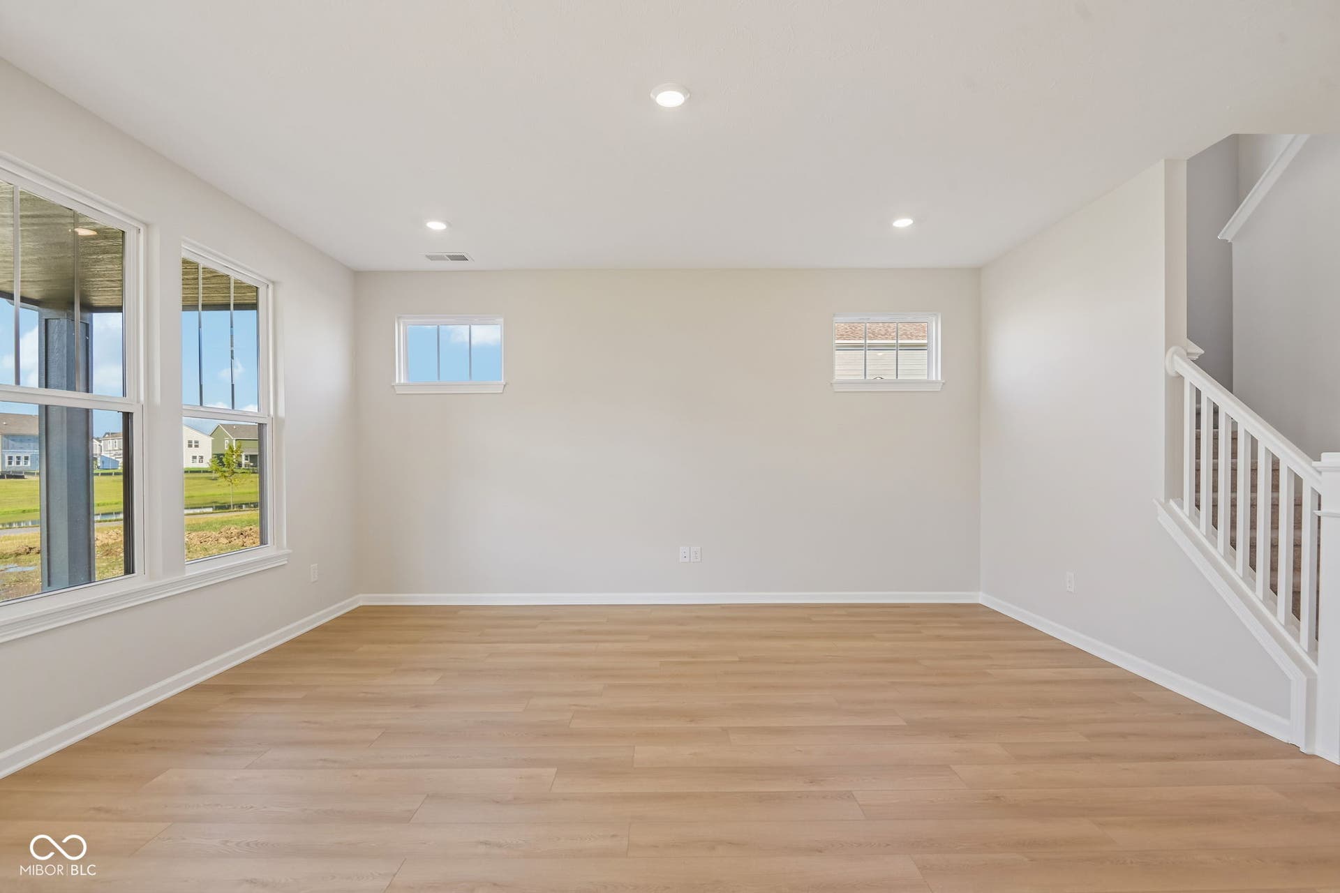 Spacious interior featuring wood-finish flooring, recessed lighting, and multiple windows